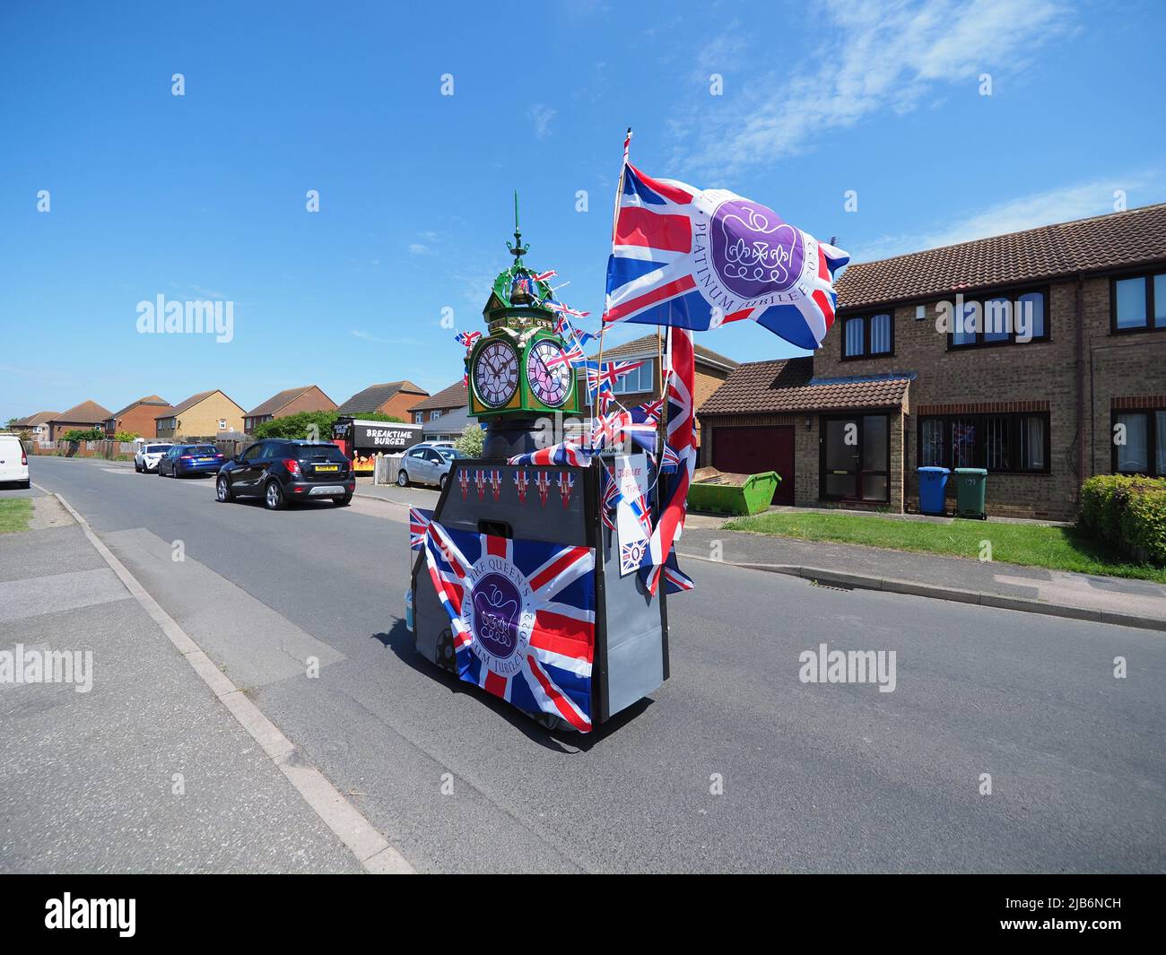 Minster on Sea, Kent, Großbritannien. 3.. Juni 2022. Tim Bell (77) von Minster on Sea, Kent, hat seinen Mobilitätsroller speziell für das Queen's Platinum Jubilee Weekend dekoriert. Der Roller verfügt über eine Nachbildung von Sheerness Uhrenturm komplett mit Glocke. Die echte Stadtuhr wurde vor kurzem speziell für das Jubiläum renoviert - aber seine Version hat eine Verhängung daran. Auf der Rückseite des Motorrollers steht „Jubilee Time“. Ziel ist es, Geld für den Krankenwagen Kent Surrey Sussex zu sammeln. Kredit: James Bell/Alamy Live Nachrichten Stockfoto