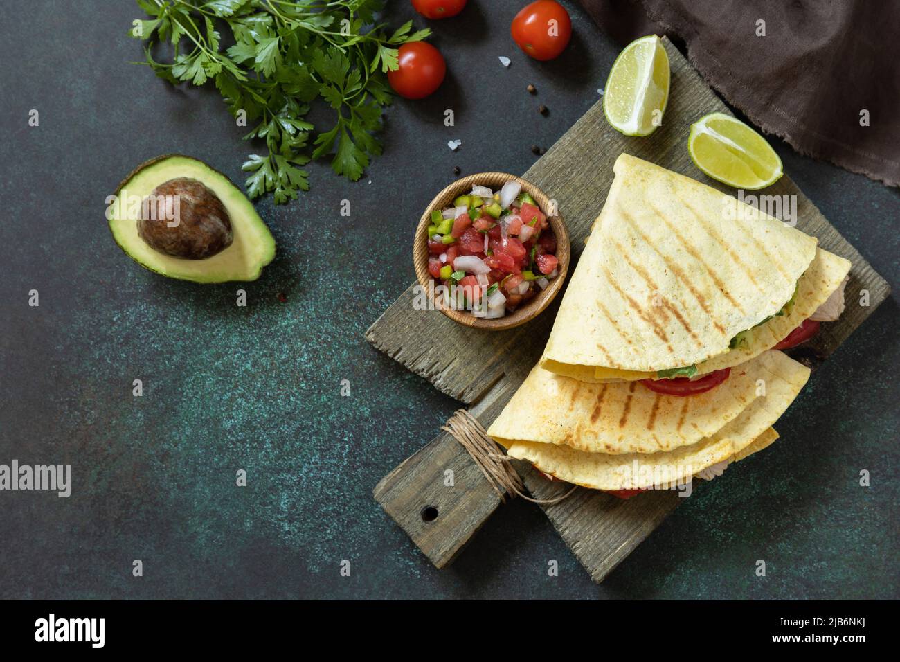 Gesundes Mittagessen. Tortilla-Sandwich, mexikanische Wraps mit gegrilltem Hähnchenfilet und Avocado, serviert mit Guacamole. Blick von oben. Speicherplatz kopieren. Stockfoto