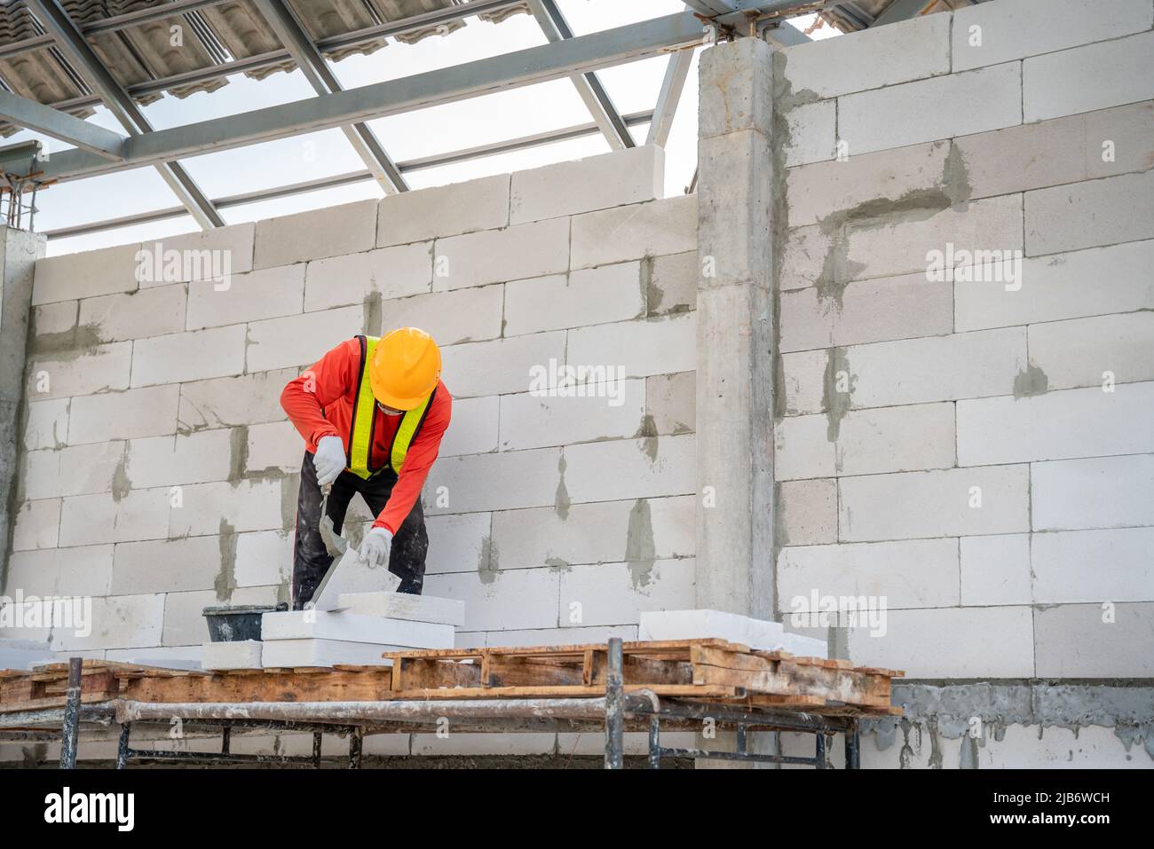 Ein Bauarbeiter verwendet Klebmörtel für leichte Mauerarbeiten auf der Baustelle. Stockfoto