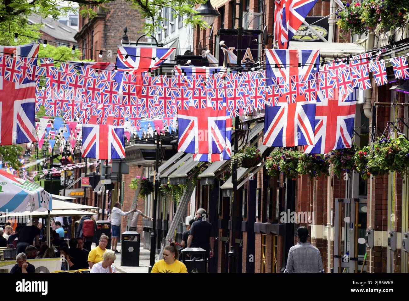 Manchester, Großbritannien, 3.. Juni 2022. Auf der Canal Street in Manchesters Schwulendorf sitzen Menschen unter vielen Union Jack-Flaggen. Tägliches Leben auf den Straßen von Manchester, England, Großbritannien und den Britischen Inseln am zusätzlichen Jubilee Bank Holiday Freitag. Am Freitag, dem 3.. Juni, ist der offizielle Bankfeiertag des Platinum Jubilee, ein zusätzlicher Bankfeiertag zur Feier des 70.-jährigen Bestehens der Königin als Monarch. Quelle: Terry Waller/Alamy Live News Stockfoto