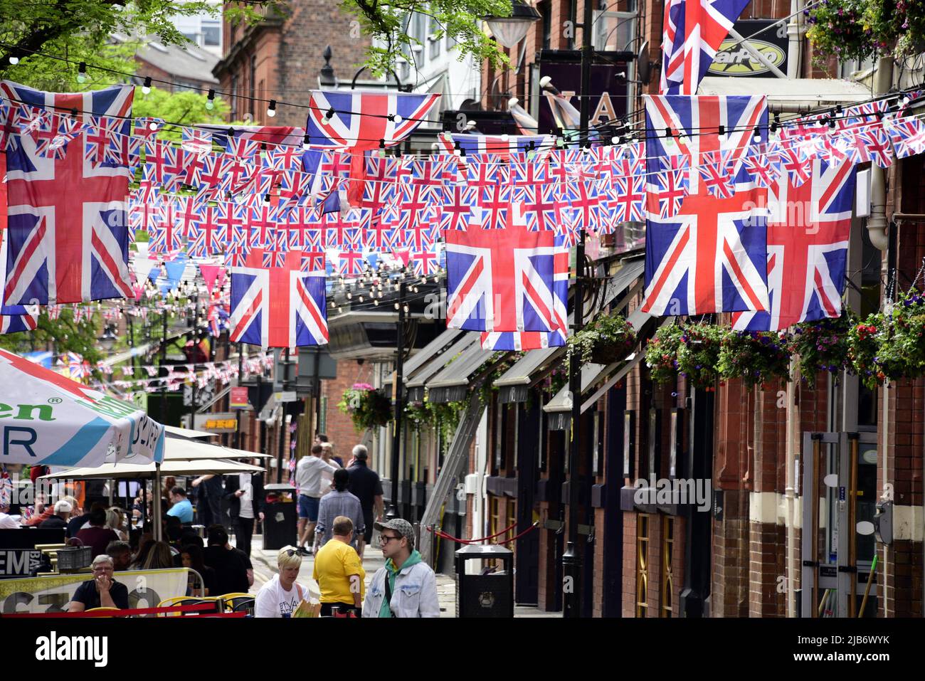 Manchester, Großbritannien, 3.. Juni 2022. Auf der Canal Street in Manchesters Schwulendorf sitzen Menschen unter vielen Union Jack-Flaggen. Tägliches Leben auf den Straßen von Manchester, England, Großbritannien und den Britischen Inseln am zusätzlichen Jubilee Bank Holiday Freitag. Am Freitag, dem 3.. Juni, ist der offizielle Bankfeiertag des Platinum Jubilee, ein zusätzlicher Bankfeiertag zur Feier des 70.-jährigen Bestehens der Königin als Monarch. Quelle: Terry Waller/Alamy Live News Stockfoto