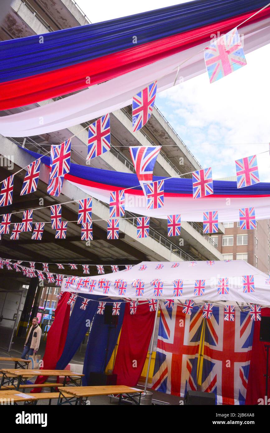 Manchester, Großbritannien, 3.. Juni 2022. Eine Person kommt an vielen Union Jack-Flaggen-Dekorationen vor der Eagle Bar in der Bloom Street in Manchesters Schwulendorf vorbei. Tägliches Leben auf den Straßen von Manchester, England, Großbritannien und den Britischen Inseln am zusätzlichen Jubilee Bank Holiday Freitag. Am Freitag, dem 3.. Juni, ist der offizielle Bankfeiertag des Platinum Jubilee, ein zusätzlicher Bankfeiertag zur Feier des 70.-jährigen Bestehens der Königin als Monarch. Quelle: Terry Waller/Alamy Live News Stockfoto