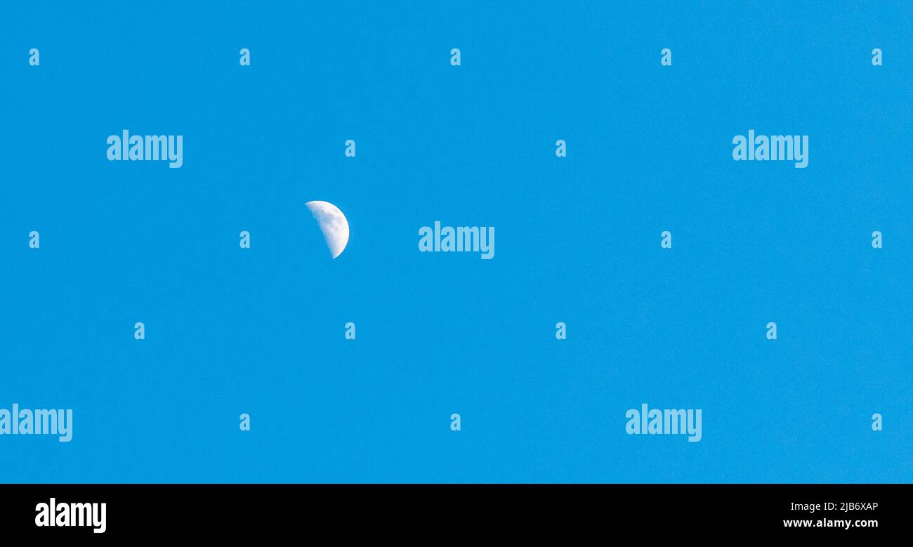 Halbmond in einem makellosen blauen Himmel Tageslicht Tag Stockfoto