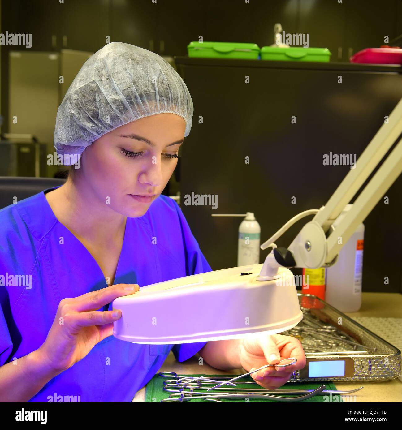 Ein Mädchen arbeitet in einem Krankenhaus als medizinische Hygienearbeiterin. In medizinischer Hygienekleidung führt sie hygienische Desinfizierende und logistische Aufgaben durch Stockfoto