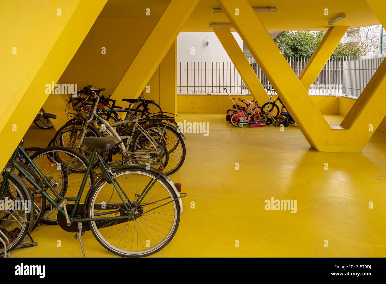 Öko-Nachbarschaft. Gelber Fahrradparkplatz in einem Wohngebäude Stockfoto