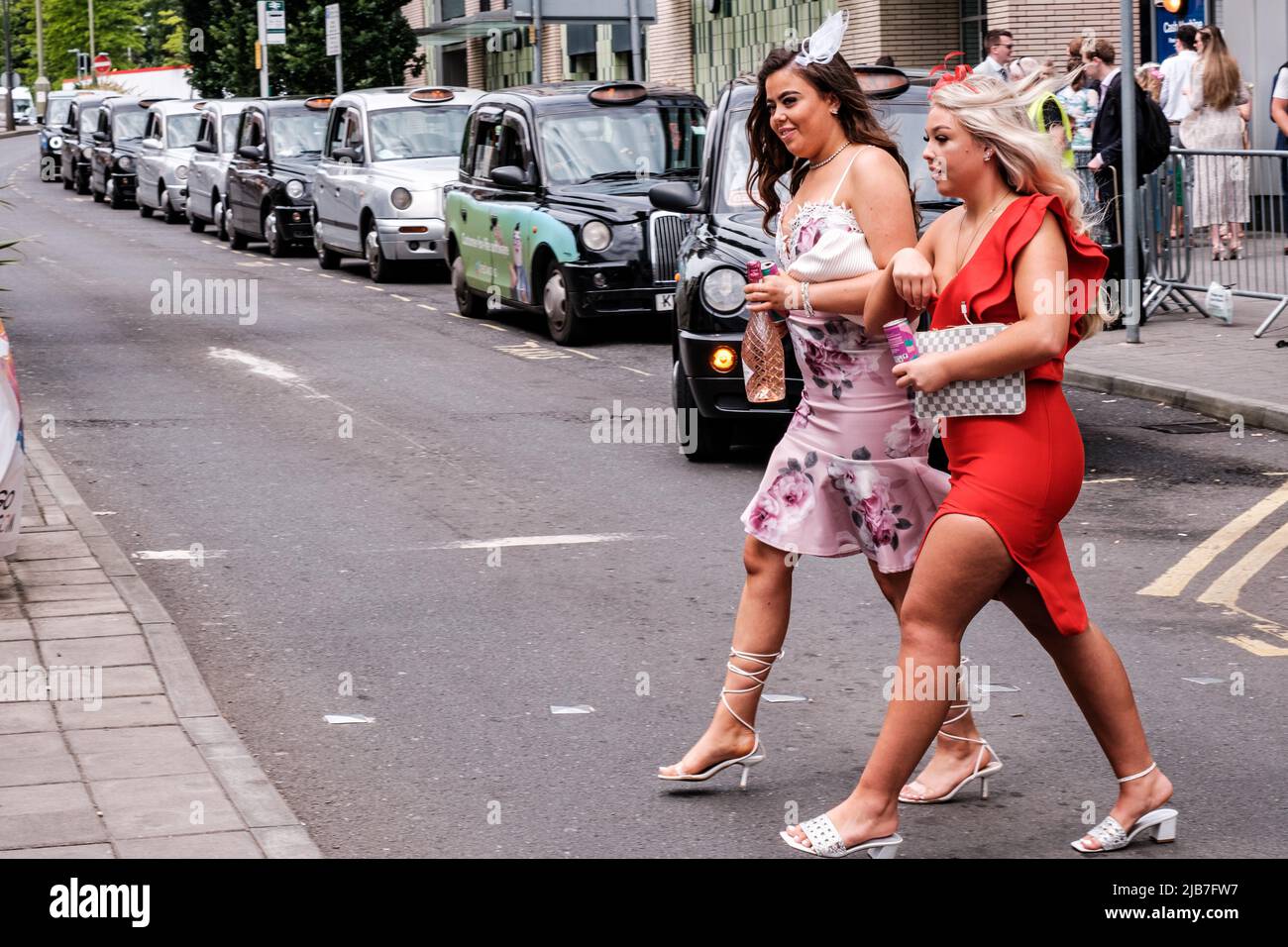 Epson Surrey, London, Großbritannien, 03 2022. Juni, Two Young Women Crossing Road in modischen engen Kleidern Stockfoto