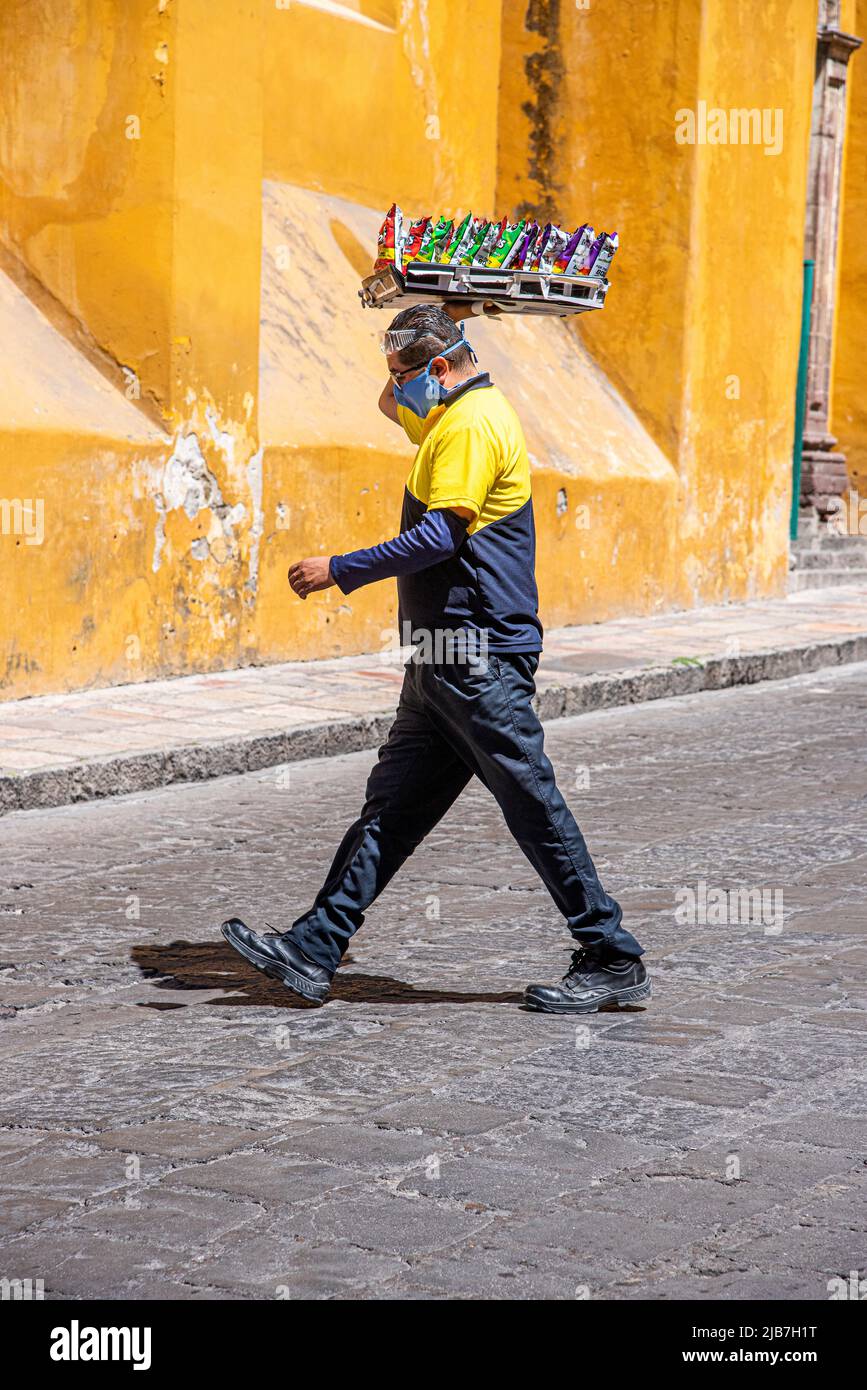 Ein Mexikaner, der über die Straße geht und ein Tablett mit Chips trägt, Guanajuato, Mexiko. Stockfoto