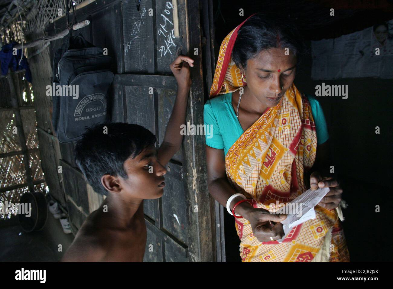 Mayna das, die Frau eines Palanquin-Portiers und ihr Sohn Joy Dev, die während der Schulprüfung ein Gespräch mit Mutter und Sohn führten. Im entlegenen Bangladesch werden Palankine immer noch zum Tragen von Bräuten verwendet. In Mathbari, einem weit entfernten Dorf in Sundarbans, Klammern sich einige Menschen immer noch an Palankins. Die Palanquin-Träger retten ein Erbe, eine jahrhundertealte Kultur des Bodens, um ihr Leben auf miserable Weise zu retten. Mathbari, Kaira, Bangladesch. 05.Mai 2007. Stockfoto