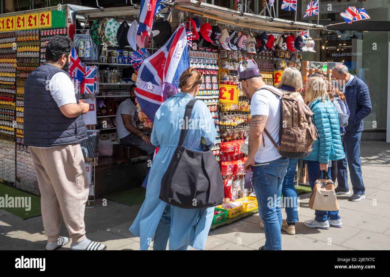 Touristen drängen sich an einem Stand, der Souvenirs in der Londoner Oxford Street verkauft Stockfoto
