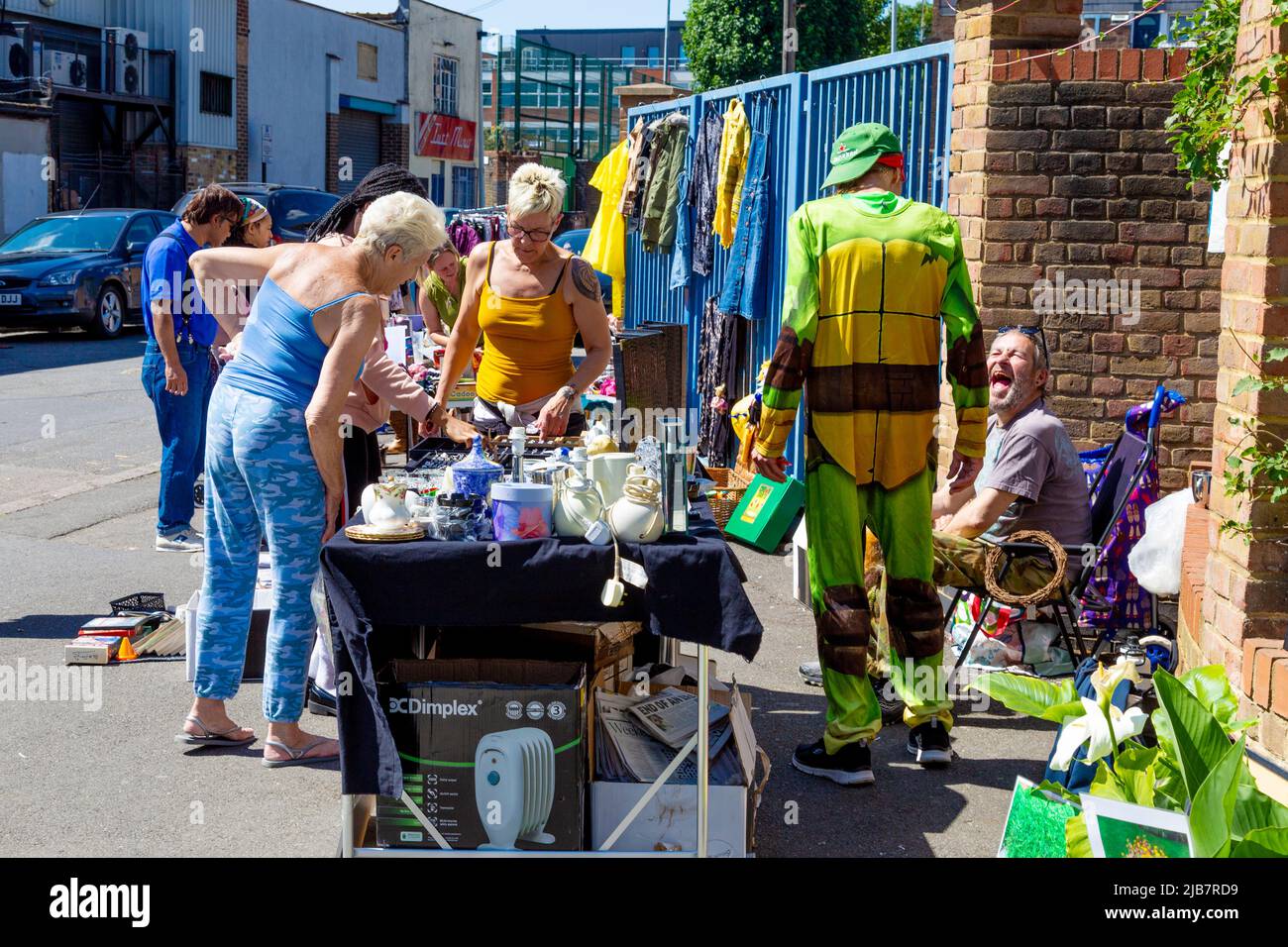 Menschen, die während eines Jumble Trail in Forest Gate, Newham, London, Großbritannien, an einem Stall einkaufen Stockfoto
