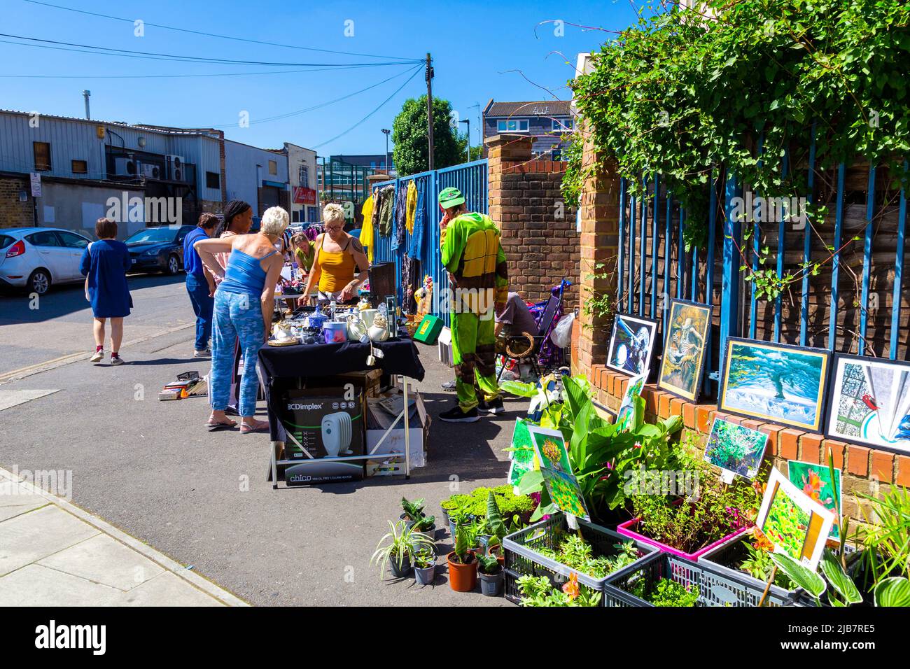 Menschen, die während eines Jumble Trail in Forest Gate, Newham, London, Großbritannien, an einem Stall einkaufen Stockfoto