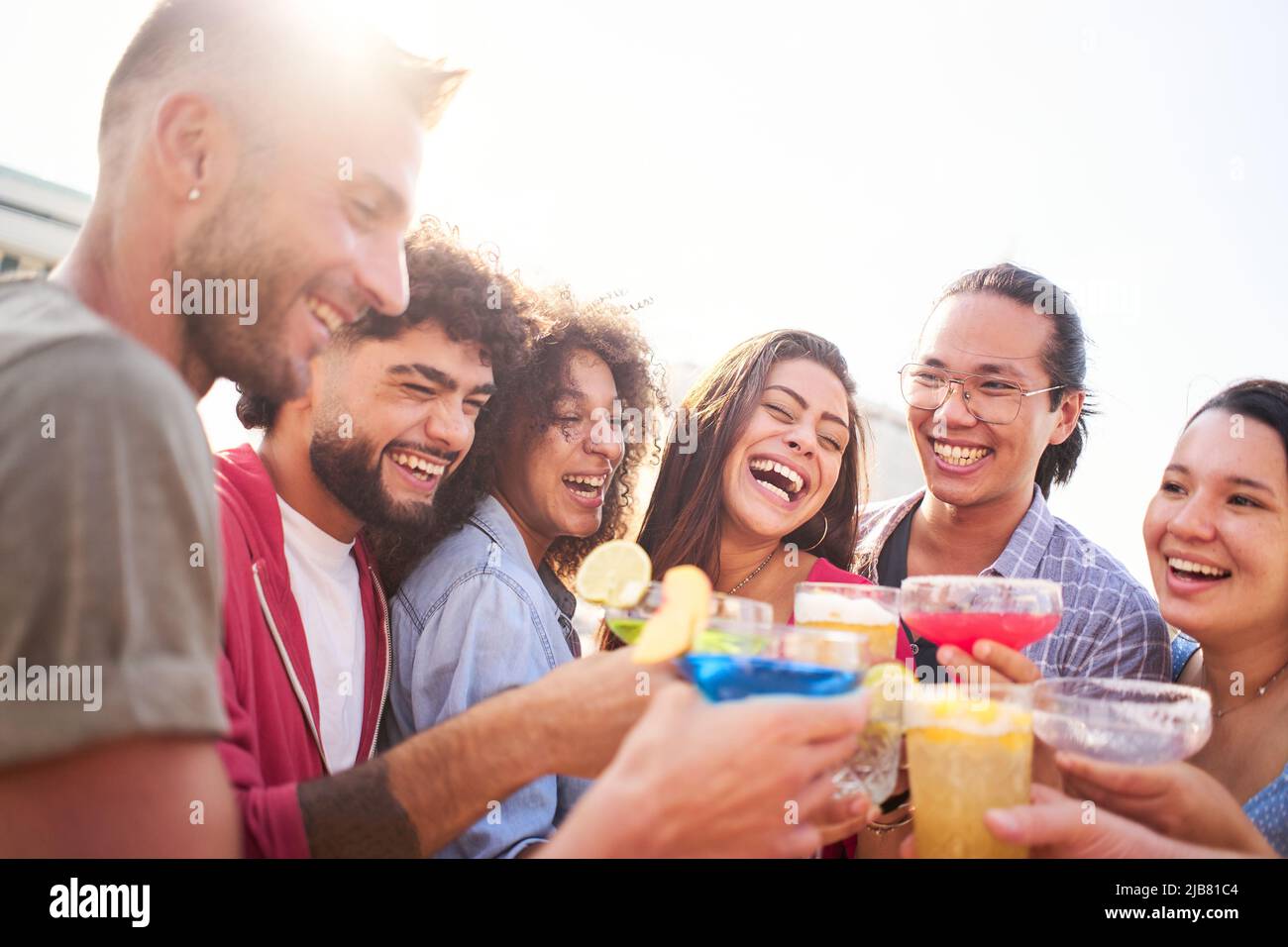 Freunde jubeln und amüsieren sich bei einem Drink in einer Bar auf dem Dach. Wir haben so viel Glück, dass wir uns gegenseitig haben. Stockfoto