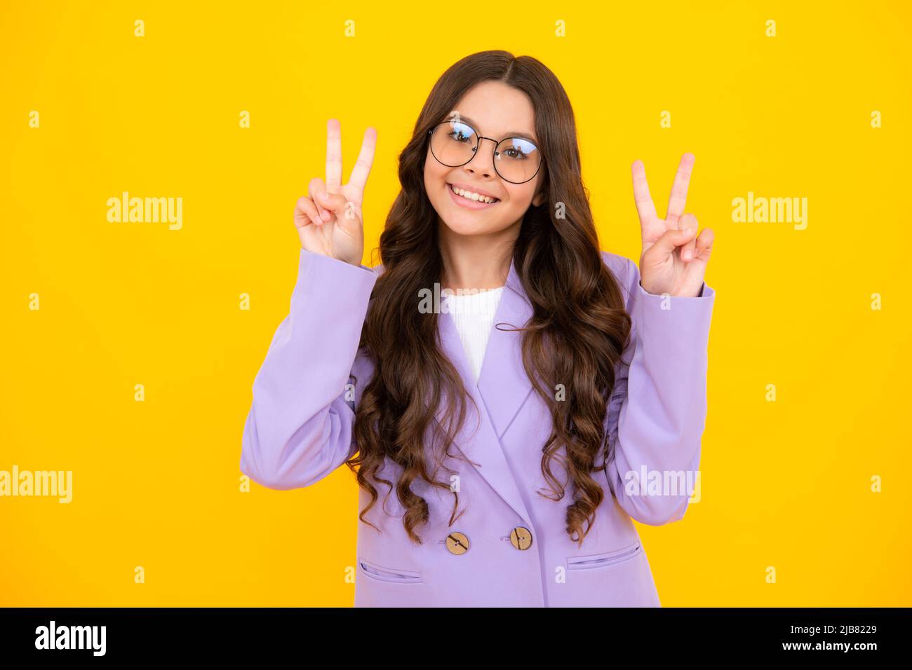 Lustige Teenager Kind Mädchen zeigen Frieden cool V-Zeichen isoliert auf gelbem Hintergrund. Stockfoto