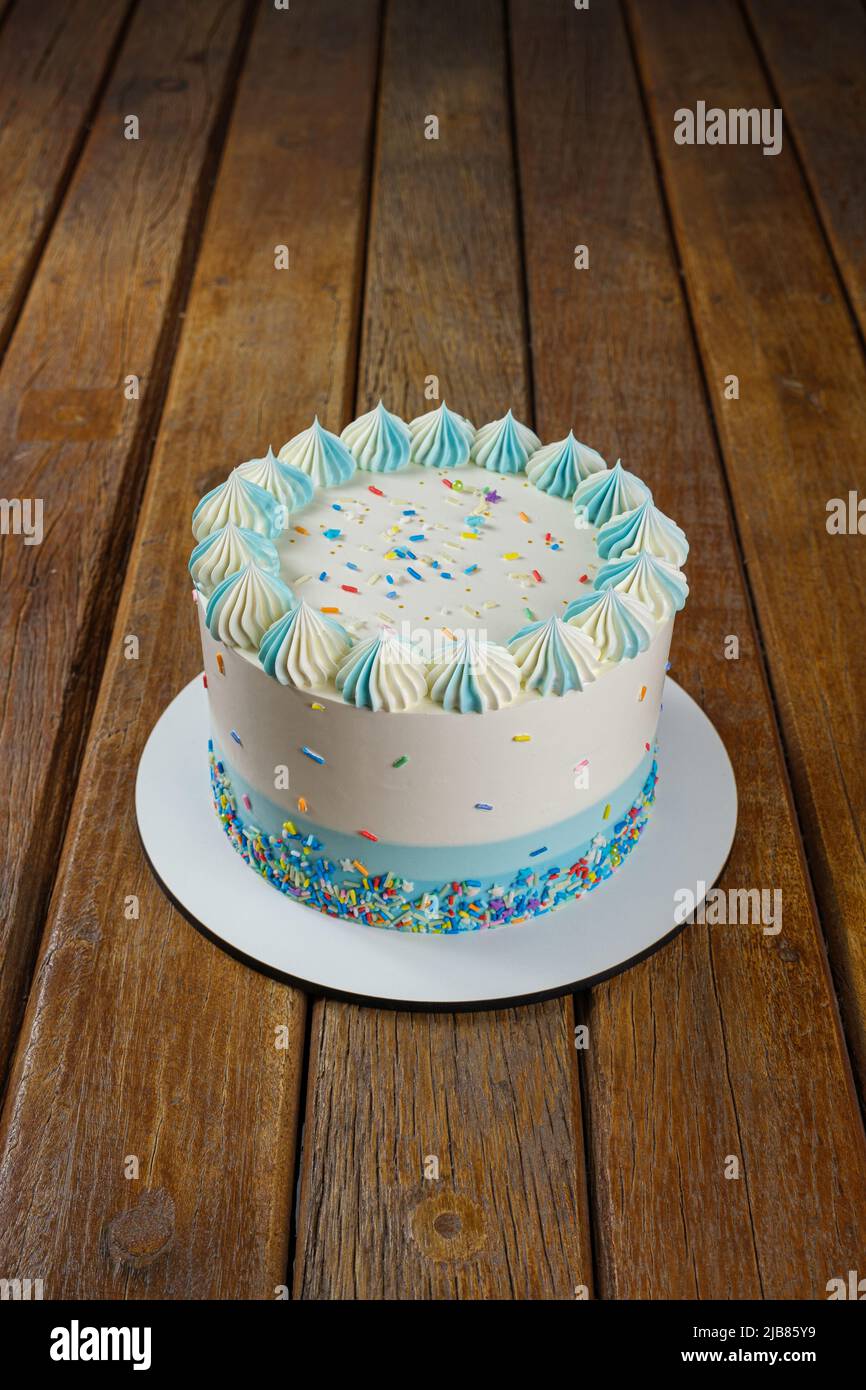 Vanillekuchen mit Buttercreme-Zuckerguss, verziert mit bunten Streuseln vertikal. Stockfoto