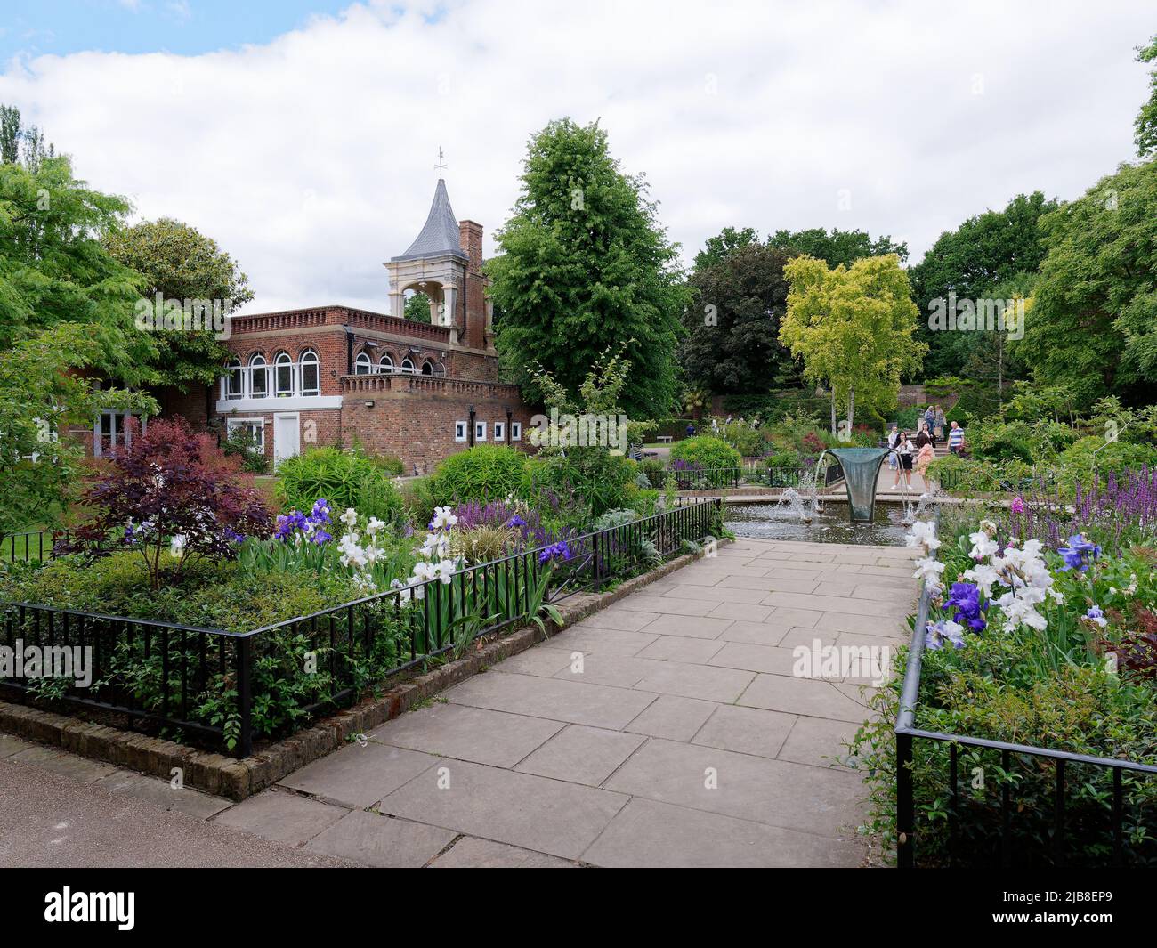London, Greater London, England, Mai 28 2022: Springbrunnen und Turm umgeben von Pflanzen und Wegen im Holland Park im Frühjahr in der Gegend von Kensington. Stockfoto