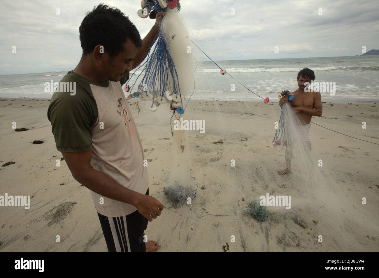 Fischer organisieren Fischernetze am Kalala Strand in Wula, Wula Waijelu, East Sumba, East Nusa Tenggara, Indonesien. Stockfoto