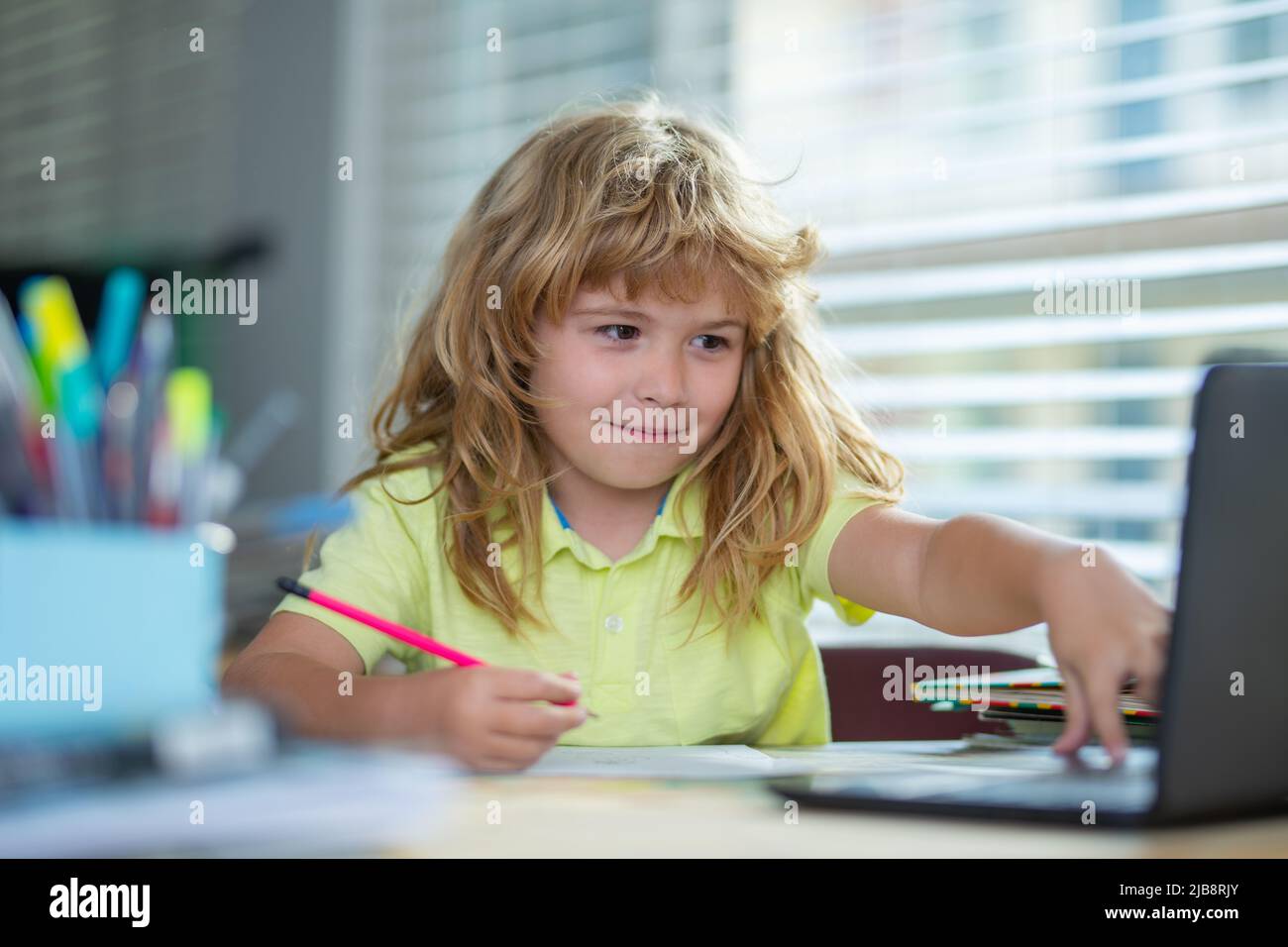 Genius Nerd Schüler Kind hat Idee. Kind schreibt in der Schule. Schuljunge macht Hausaufgaben schreiben und lesen zu Hause. Konzentriertes Schreiben von Kindern Stockfoto