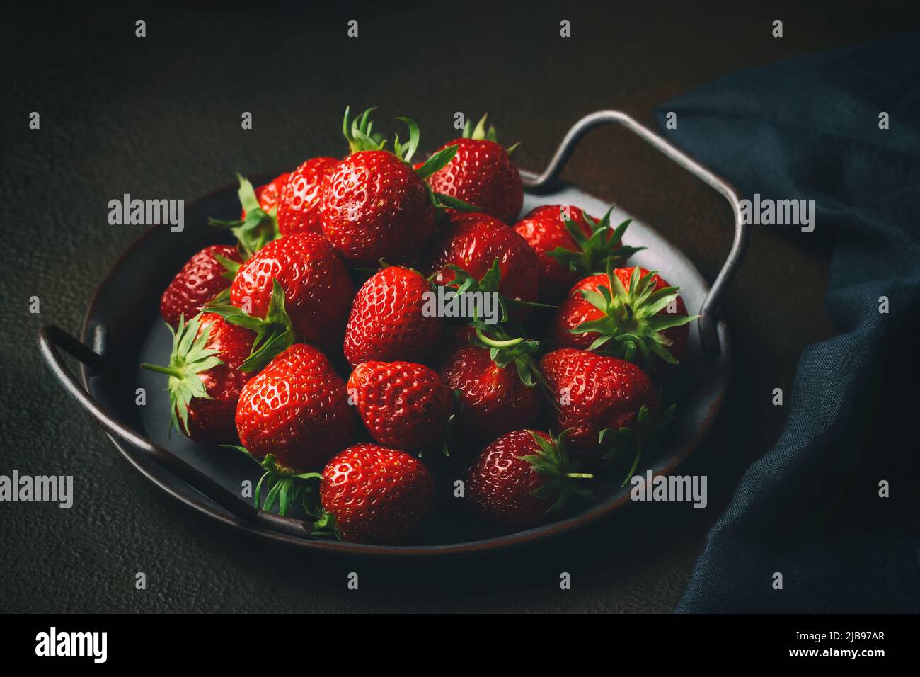 Reife frisch gezüchte natürliche Erdbeeren auf einem Metalltablett auf dem Tisch Stockfoto