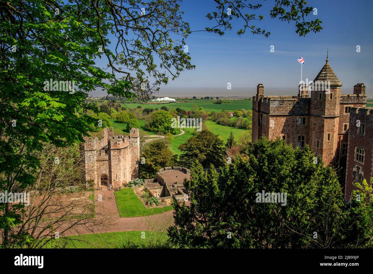 Dunster Castle mit dem Bristol Channel und einem Dampfzug der West Somerset Railway, Somerset, England, Großbritannien Stockfoto