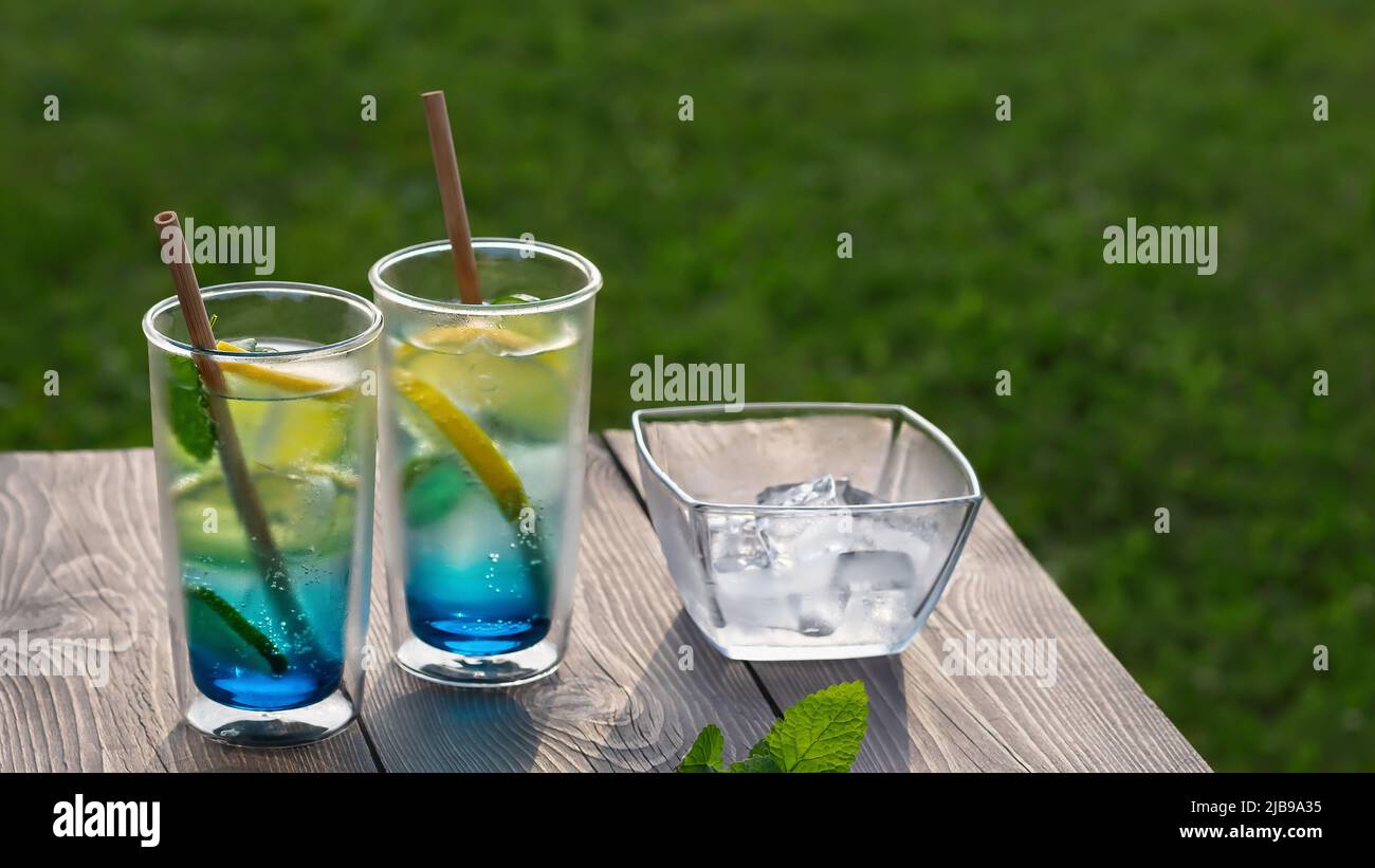 Zwei Gläser mit einem kühlen blauen Lagunencocktail auf einem Holztisch. Selektiver Fokus. Stockfoto