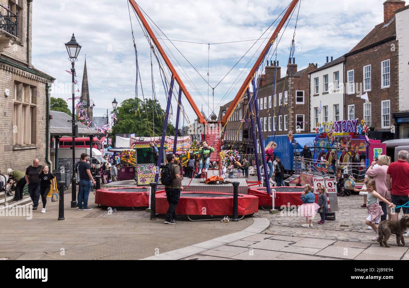 Kinder, die auf den Fahrgeschäften usw. auf dem Jahrmarkt bei den Queens Jubilee Celebrations auf dem Marktplatz in Darlington, England, Großbritannien, spielen Stockfoto
