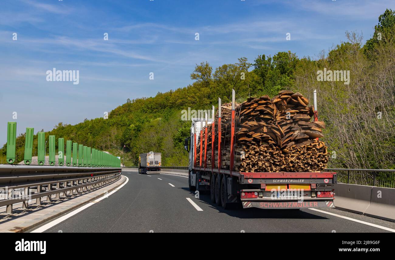 Ein Bild eines LKW, der Baumrinken oder Holz auf einer slowenischen Autobahn trägt. Stockfoto