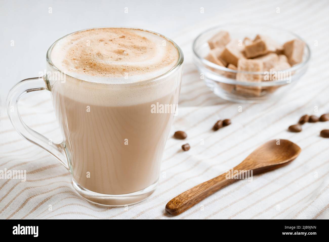 Latte-Kaffee mit Schaum auf einem hellen Küchentisch Stockfoto