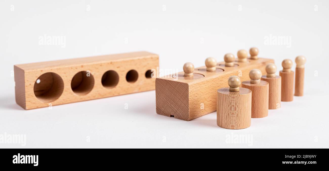 Montessori klopften Holzzylinder mit Blöcken. Kinder rätseln für die Entwicklung der Dimensionswahrnehmung. Hochwertige Fotos Stockfoto