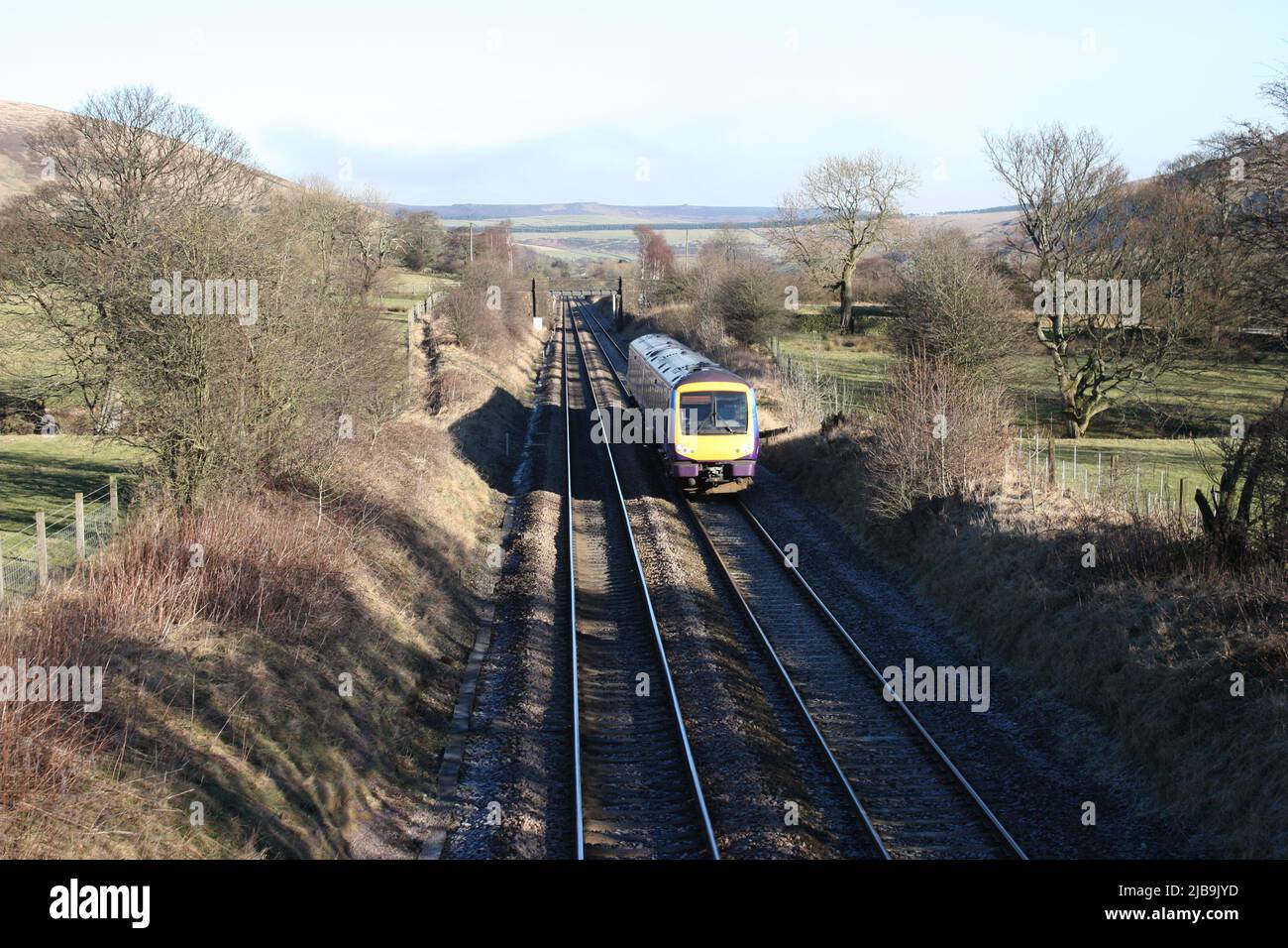 Ein Dieselzug auf einer entlegener Landeisenbahn. Stockfoto