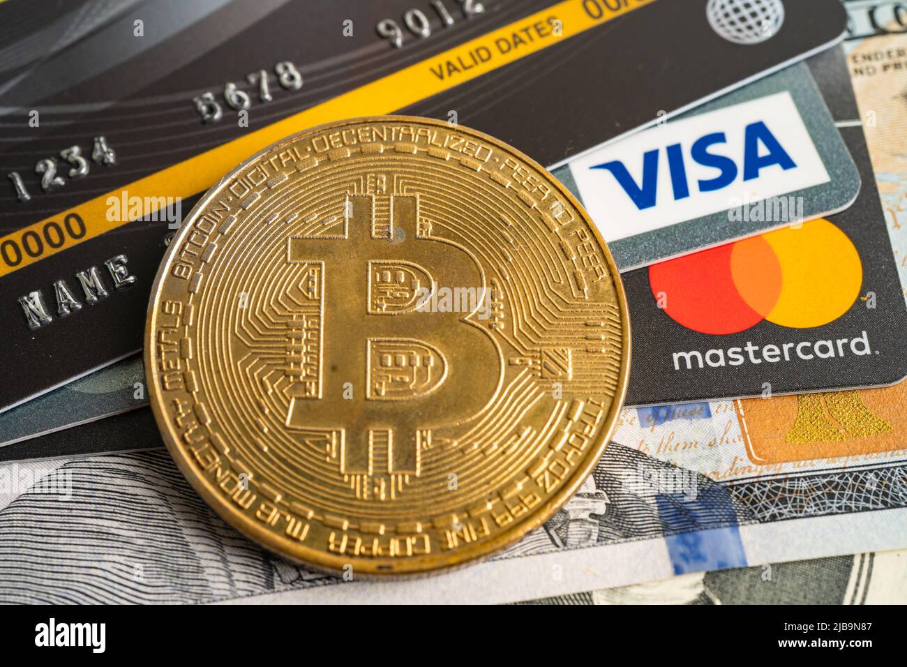 Bangkok, Thailand, 9. Juli 2021, Goldbitcoin mit Kreditkarte auf US-Dollar-Banknoten für elektronischen weltweiten Austausch virtuelles Geld, Blockchain, weinen Stockfoto