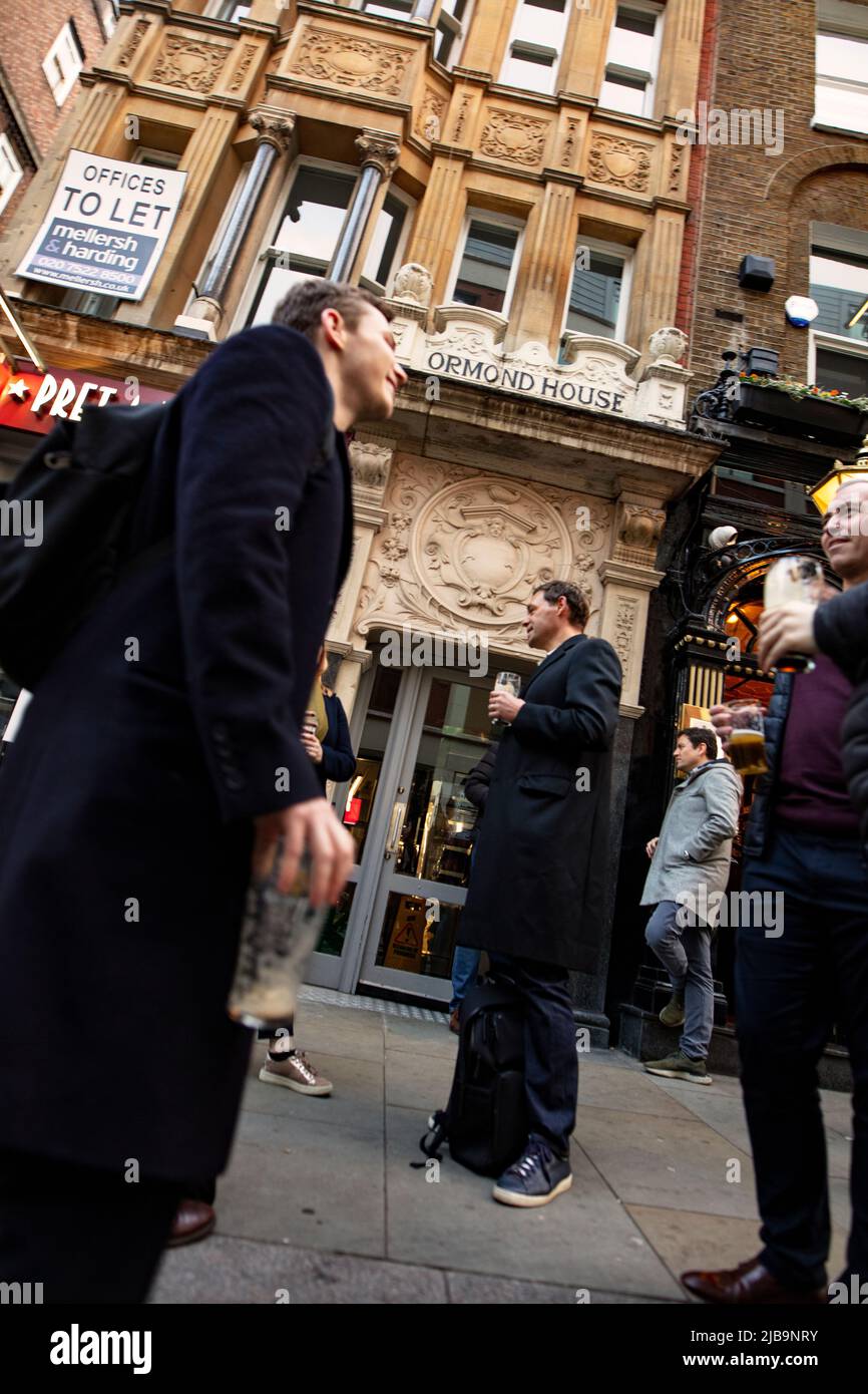 Menschen, die am heißen Sommertag vor dem Red Lion Pub in der Duke of York St, St James, London stehen Stockfoto