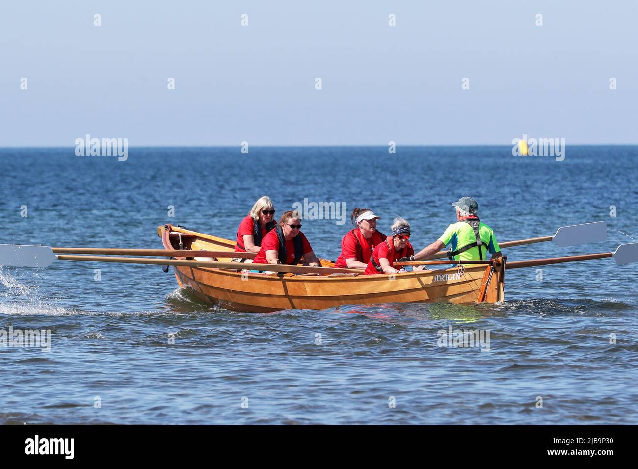 Troon, Großbritannien. 04.. Juni 2022. 04. Juni 2022. Troon, Großbritannien. Der Troon Coastal Rowing Club (TCRC) veranstaltete seine jährliche Regatta auf dem Firth of Clyde, der vom Südstrand Troon, Ayrshire, Großbritannien, aus segelte. Die kleinen Boote sind traditionell, handgefertigt, aus Holz, 4 Crew, Angeln Skiffs, Basierend auf einem 300 Jahre alten Design. Das Rennen erfordert, dass die Teilnehmer eine festgelegte Strecke von nicht weniger als 2 Kilometern zurücklegen, vom Ufer aus und bei der Rückkehr muss ein Teammitglied einen Stock Troon Rock (Süßwaren}) nehmen und mit ihm bis zur Ziellinie laufen. Die Veranstaltung zog Teilnehmer aus verschiedenen Ruderclubs an der Küste Schottlands an Stockfoto