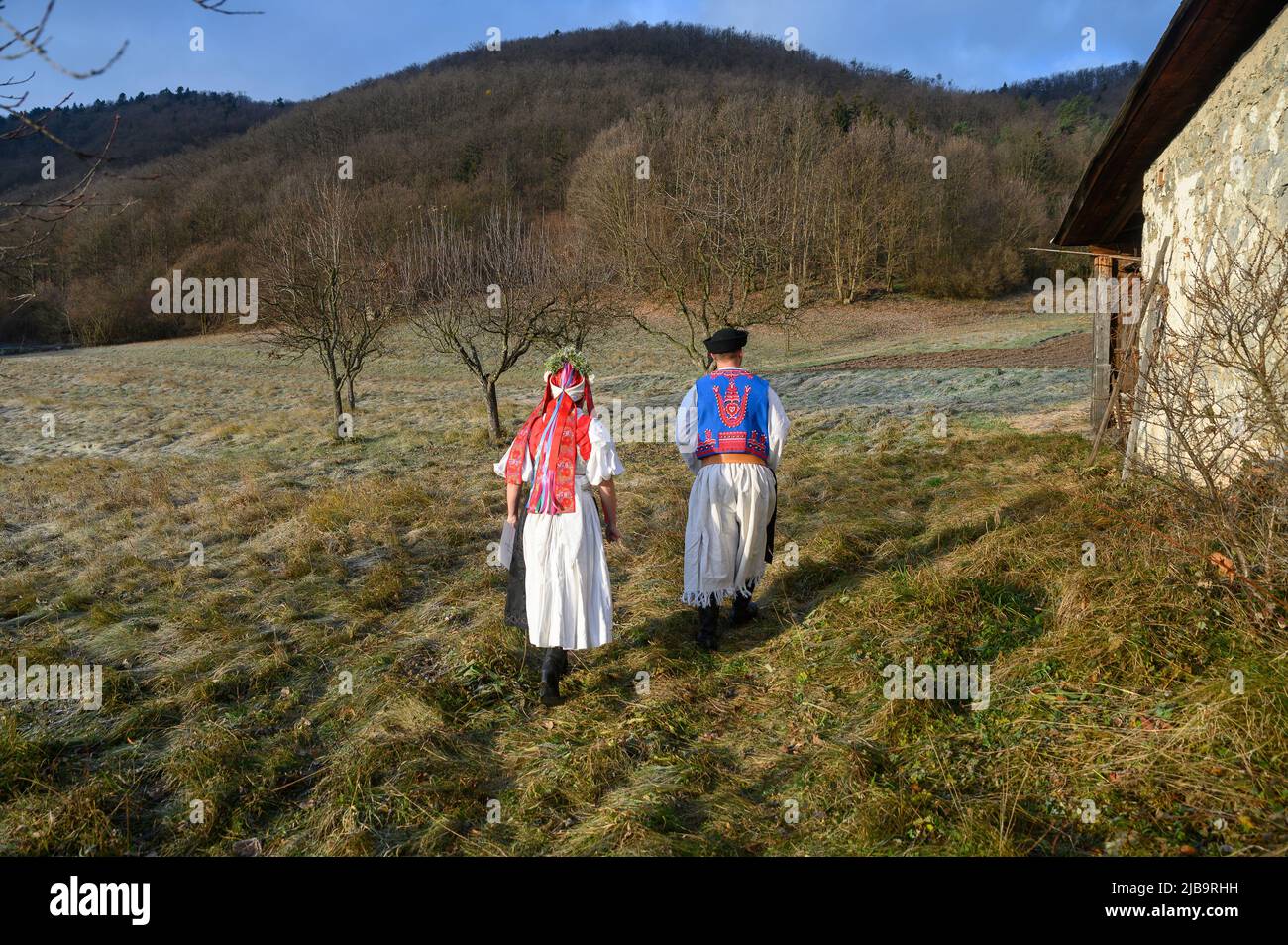 Ein Paar in traditioneller Tracht. Slowakische Kostüm im Herbst Natur. Altes Landhaus im Hintergrund. Junges Paar in Tracht Wal Stockfoto