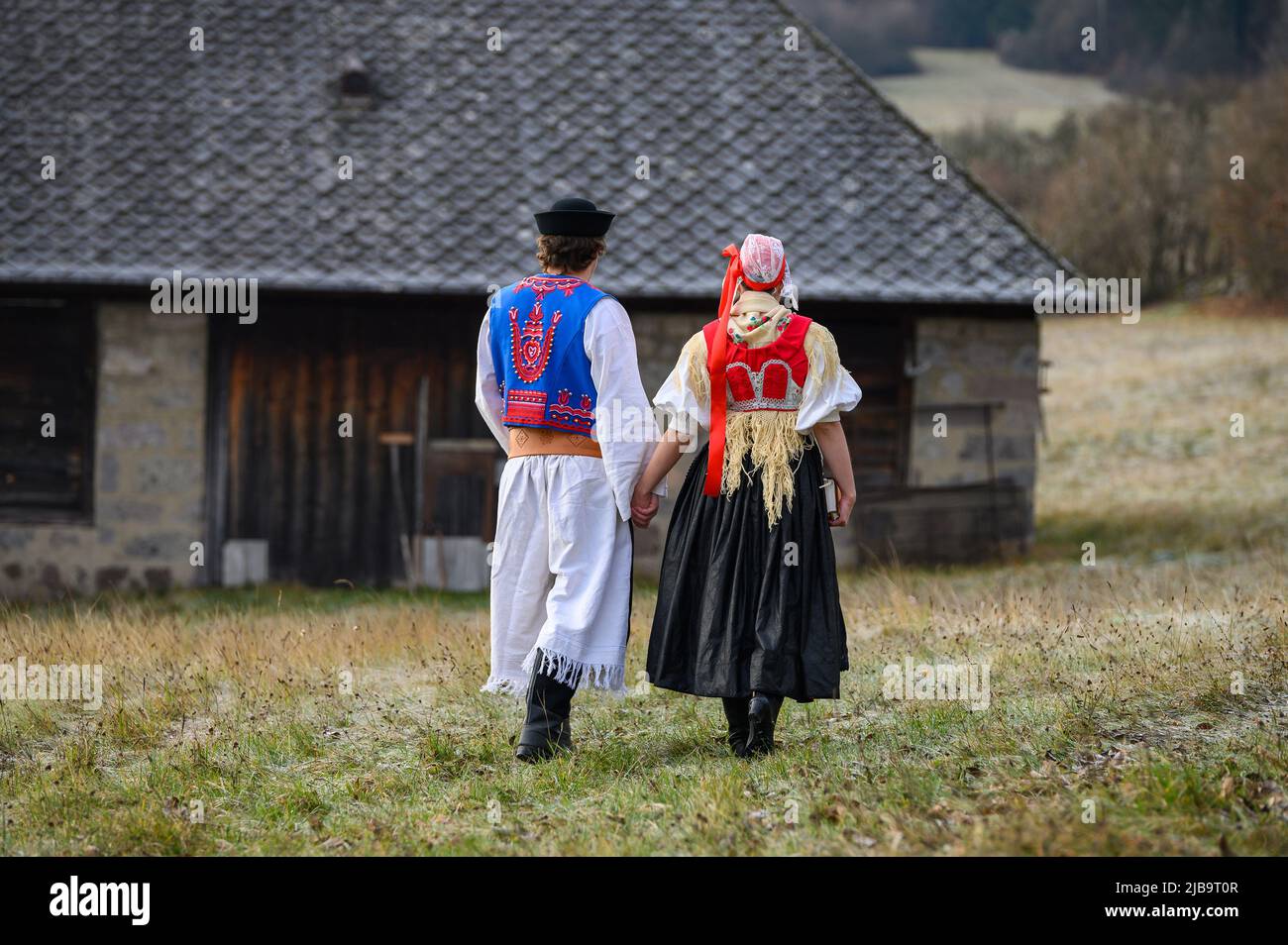 Ein Paar in traditioneller Tracht. Slowakische Kostüm im Herbst Natur.  Altes Landhaus im Hintergrund. Junges Paar in Tracht Wal Stockfotografie -  Alamy