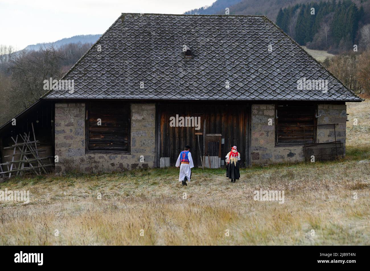 Ein Paar in traditioneller Tracht. Slowakische Kostüm im Herbst Natur. Altes Landhaus im Hintergrund. Junges Paar in Tracht Wal Stockfoto