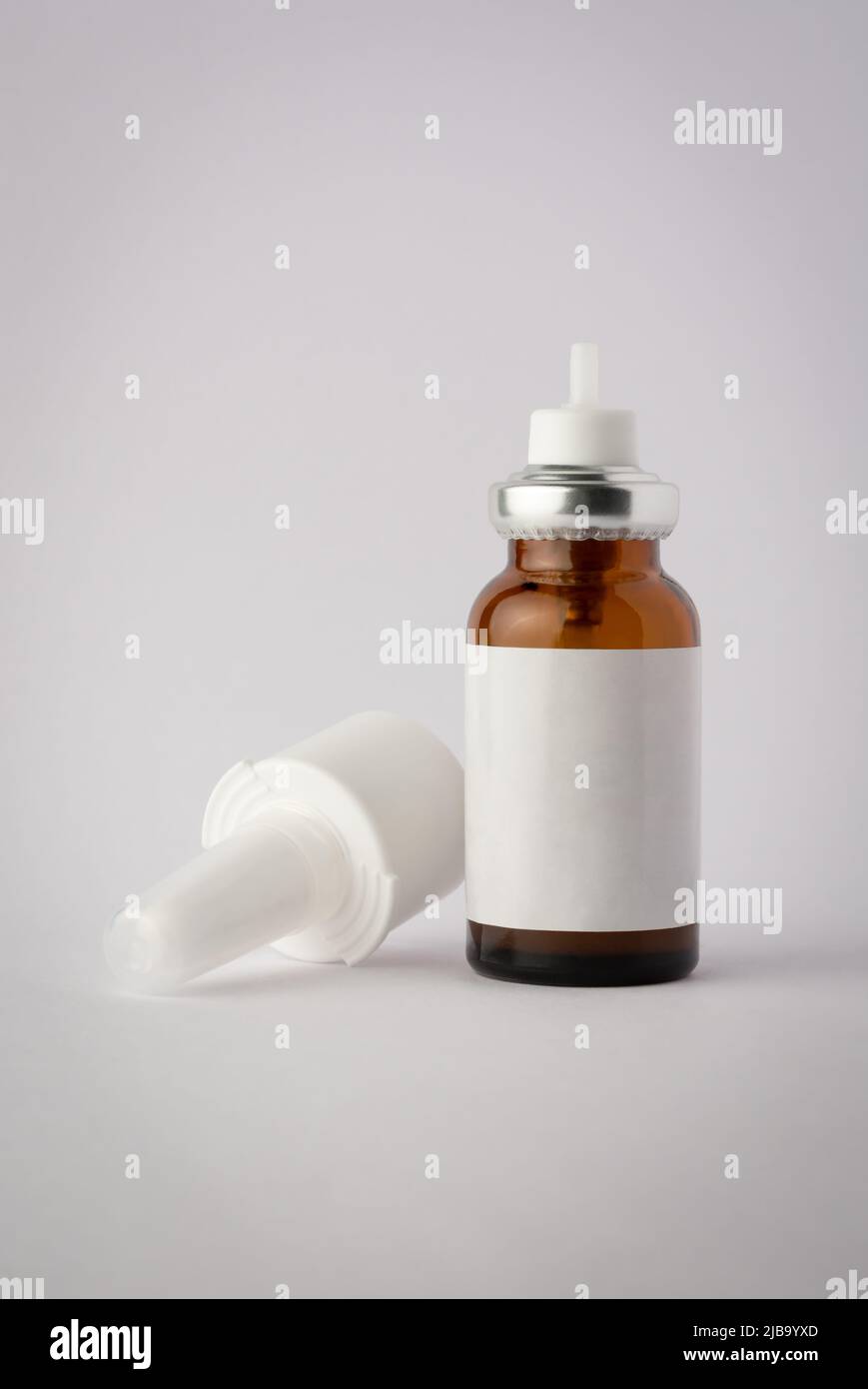 Braune Glas Nasenspray Flasche Mockup, medizinische Feuchtigkeitscreme für Grippe und Allergien, pharmazeutische Aerosol mit Pumpe auf einem neutralen grauen Hintergrund Stockfoto