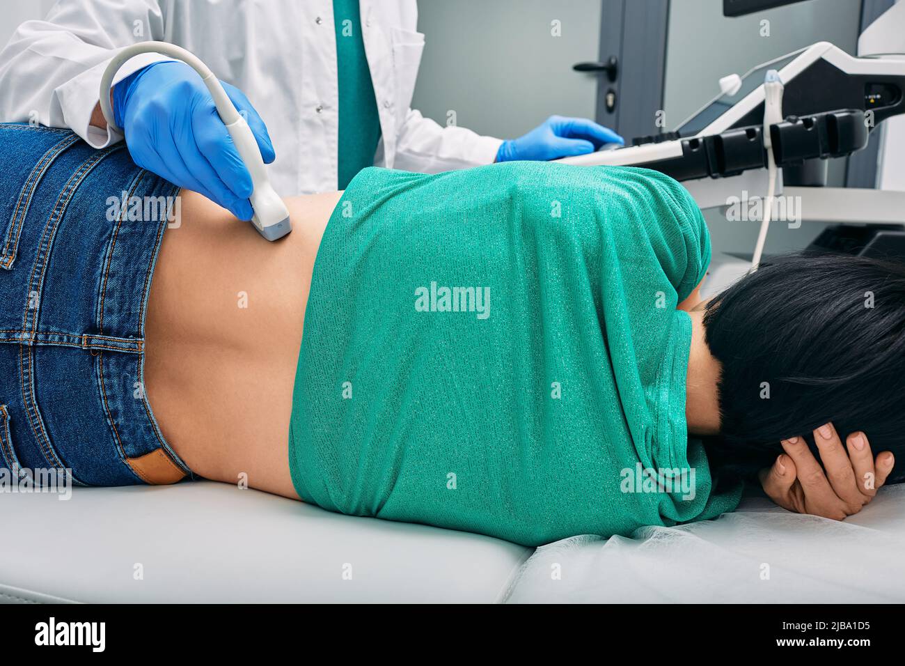 Ultraschall der Nieren. Patientin während der Ultraschalluntersuchung in der Klinik seitlich liegend, Blick von hinten Stockfoto