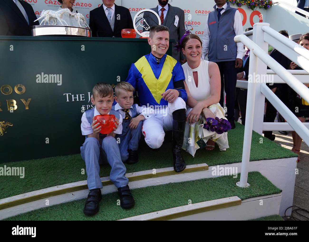Jockey Richard Kingscote mit der Trophäe und seiner Familie nach dem Gewinn des Cazoo Derby (in Erinnerung an Lester Piggott) mit Desert Crown am Derby Day während des Cazoo Derby Festivals 2022 auf der Epsom Racecourse, Surrey. Bilddatum: Samstag, 4. Juni 2022. Stockfoto