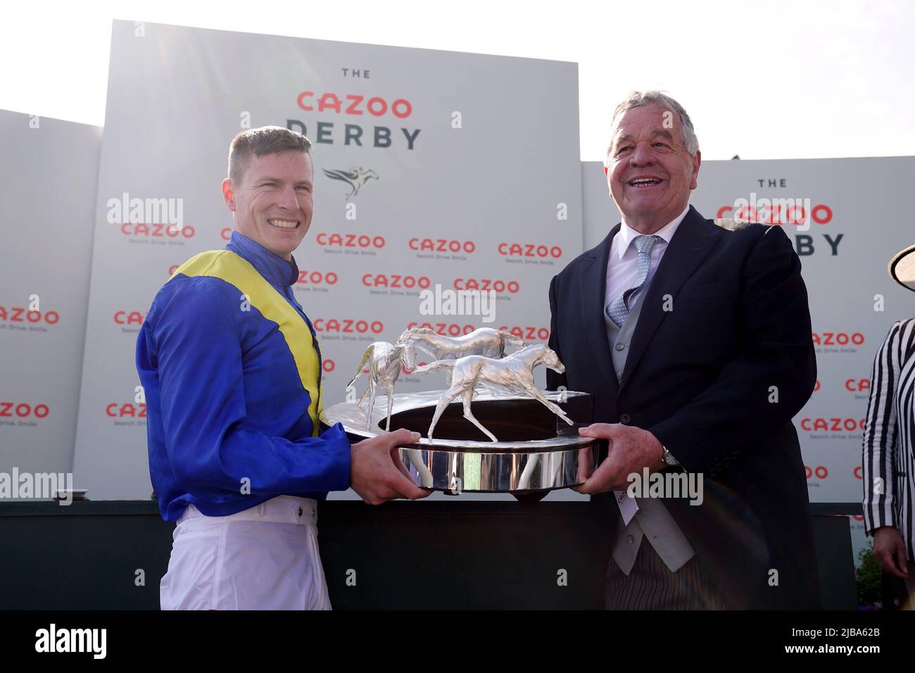 Jockey Richard Kingscote und Trainer Sir Michael Stoute mit der Trophäe nach dem Gewinn des Cazoo Derby (in Erinnerung an Lester Piggott) mit Desert Crown am Derby Day während des Cazoo Derby Festivals 2022 auf der Epsom Racecourse, Surrey. Bilddatum: Samstag, 4. Juni 2022. Stockfoto