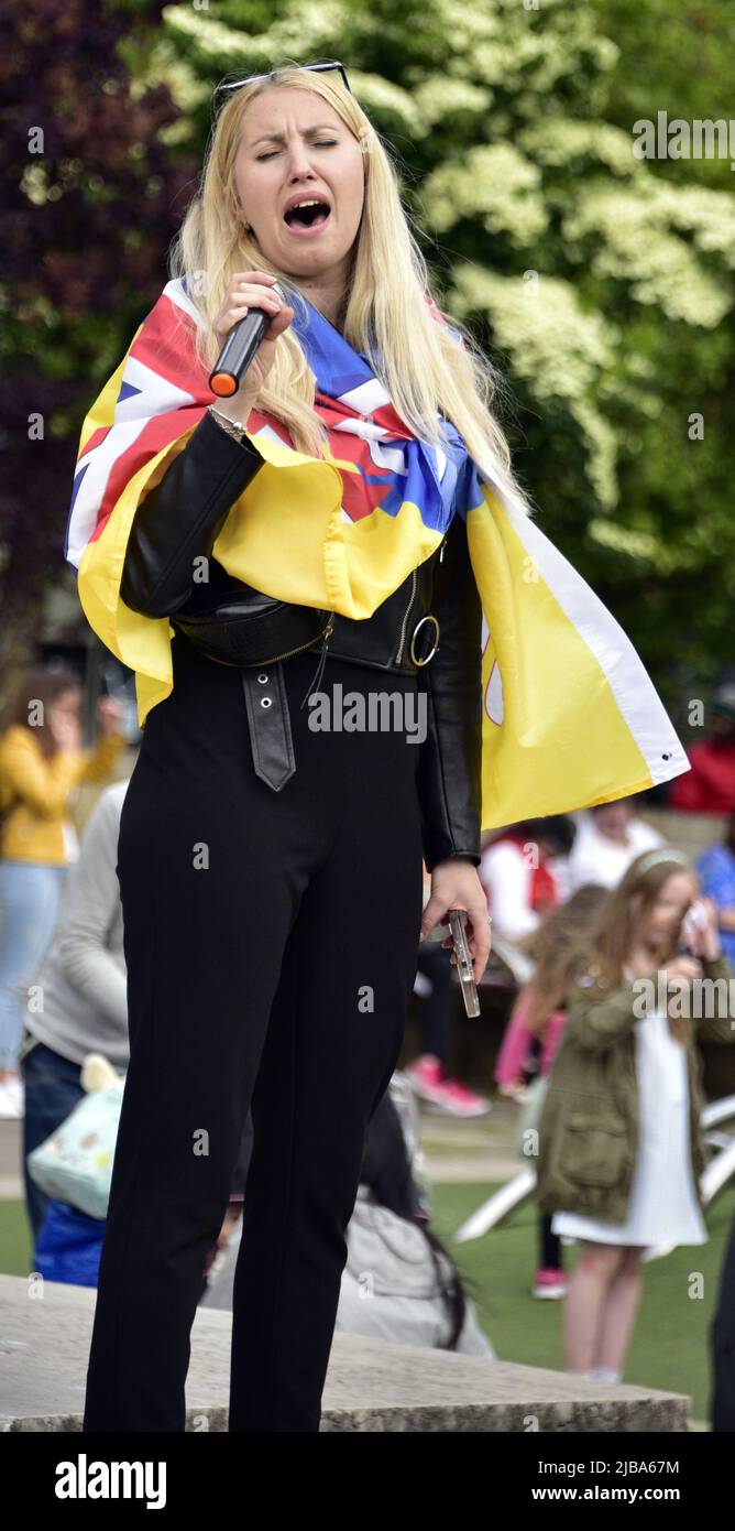 Manchester, Großbritannien, 4.. Juni 2022. Eine Protesterin singt ein ukrainisches Lied. Anti-Kriegs-Kundgebung „steht mit der Ukraine“, ein Protest gegen die russische Invasion der Ukraine in Piccadilly Gardens, im Zentrum von Manchester, England, Großbritannien und den Britischen Inseln. Dies ist der sechzehnte Samstag, an dem der Protest stattgefunden hat. Die Proteste werden vom Ukrainischen Kulturzentrum „Dnipro“ Manchester organisiert. Quelle: Terry Waller/Alamy Live News Stockfoto