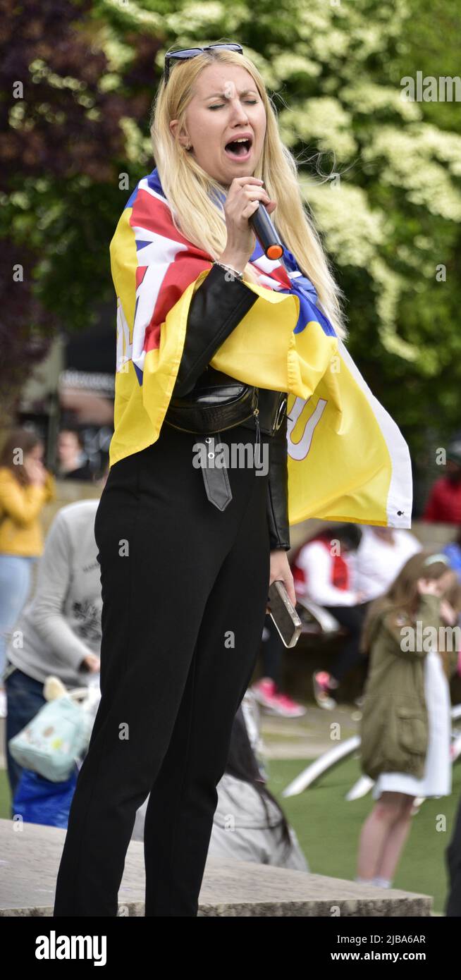 Manchester, Großbritannien, 4.. Juni 2022. Eine Protesterin singt ein ukrainisches Lied. Anti-Kriegs-Kundgebung „steht mit der Ukraine“, ein Protest gegen die russische Invasion der Ukraine in Piccadilly Gardens, im Zentrum von Manchester, England, Großbritannien und den Britischen Inseln. Dies ist der sechzehnte Samstag, an dem der Protest stattgefunden hat. Die Proteste werden vom Ukrainischen Kulturzentrum „Dnipro“ Manchester organisiert. Quelle: Terry Waller/Alamy Live News Stockfoto