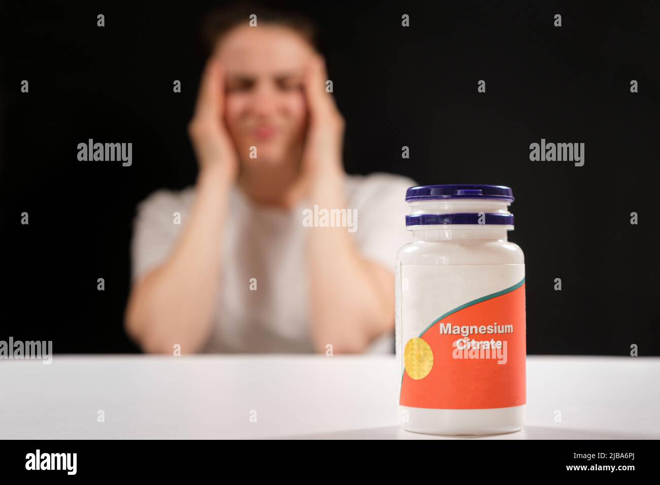 Eine müde Frau und ein Glas Magnesiumcitrat. Nahrungsergänzungsmittel gegen Müdigkeit, Reizbarkeit und Schlaflosigkeit Stockfoto