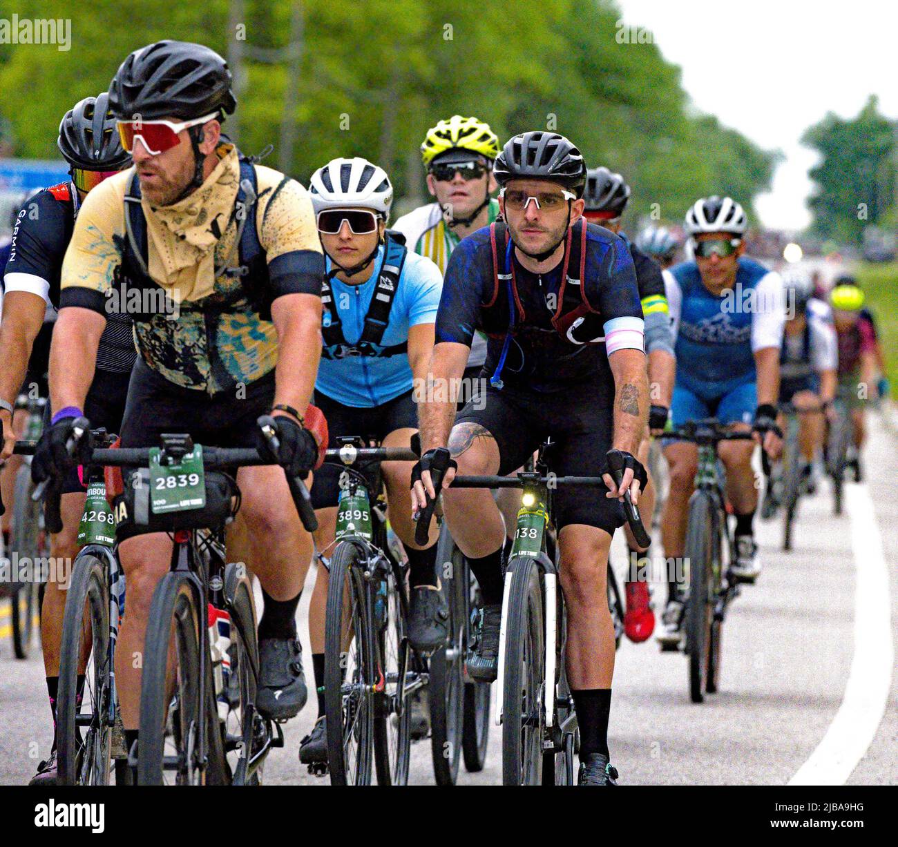 EMPORIA, KANSAS - 4. JUNI 2022 Unbound Gravel Rider erhalten einen 7:00-Start auf den 100 Meilen des zweiten Rennens des Tages. Hier an der südlichen Stadtgrenze von Emporia, Kansas, gesehen, 4. Juni 2002 kurz vor der Überquerung der Cottonwood-Flussbrücke und der Abzweigung der asphaltierten Straße auf den ersten Schotterweg Stockfoto