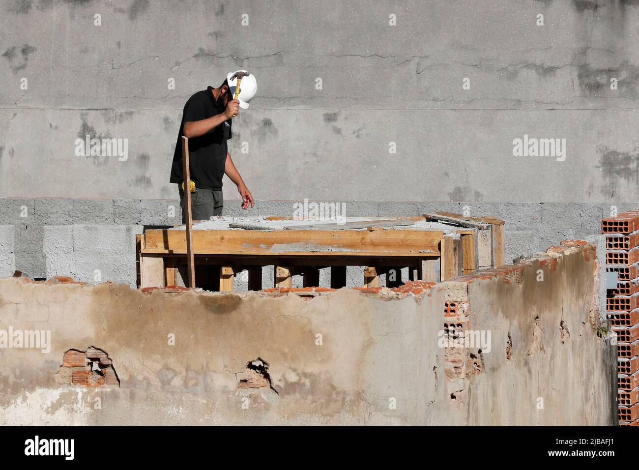 Zimmermann, Bauarbeiter. Arbeiter renovieren Dach des Gebäudes. Hausreparatur im Bau. Mann bei der Arbeit auf dem Dach Stockfoto