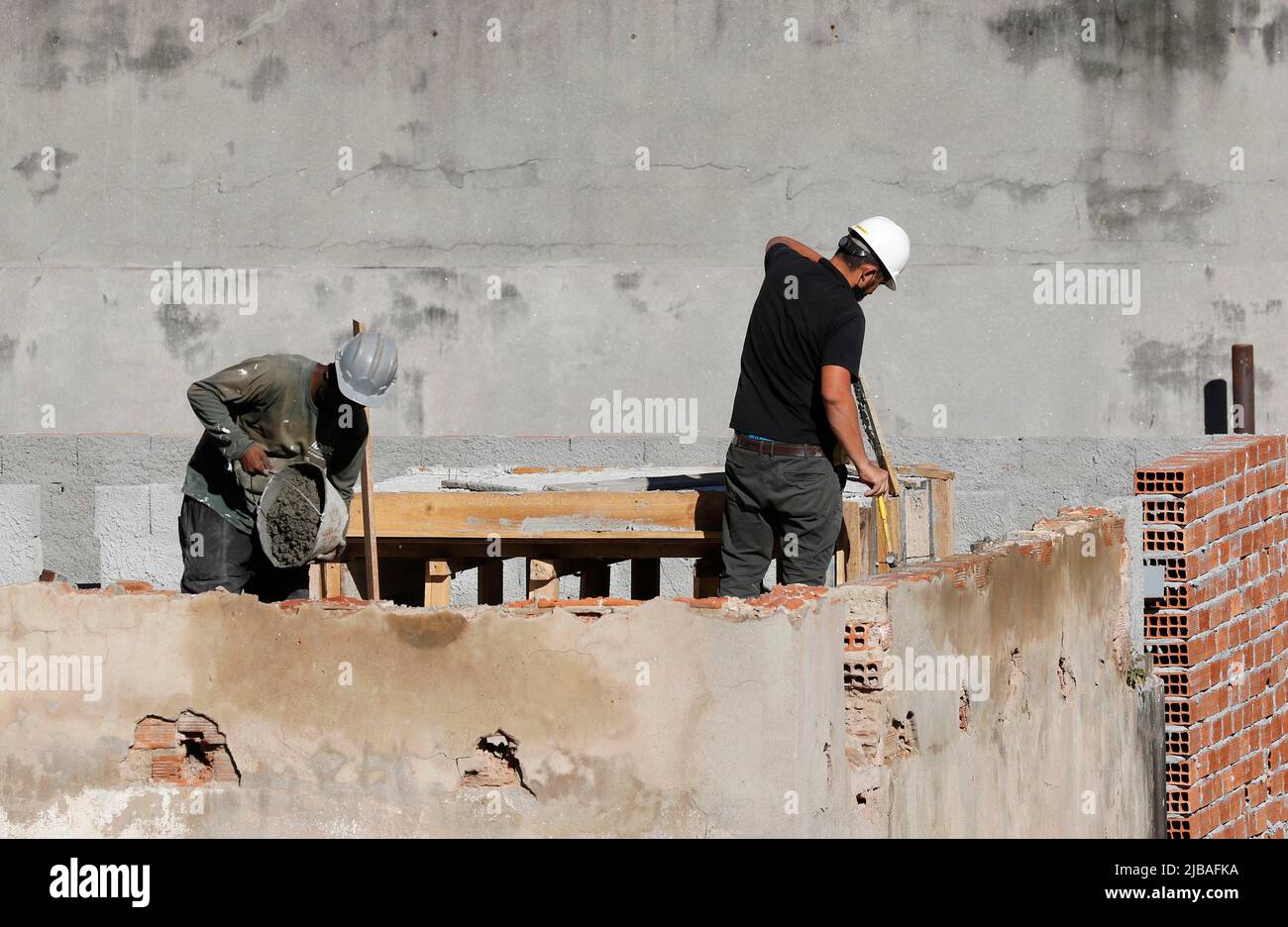 Zimmermann, Bauarbeiter. Arbeiter renovieren Dach des Gebäudes. Hausreparatur im Bau. Mann bei der Arbeit auf dem Dach Stockfoto