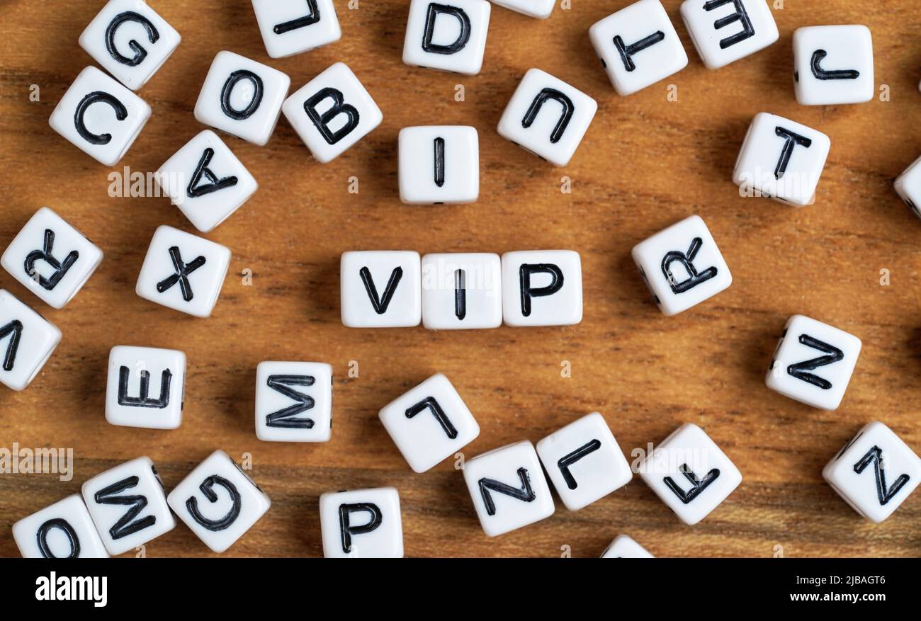 Kleine weiße und schwarze Perlenwürfel auf Holzbrett, Buchstaben in der Mitte buchstabieren VIP - sehr wichtiges Personenkonzept Stockfoto