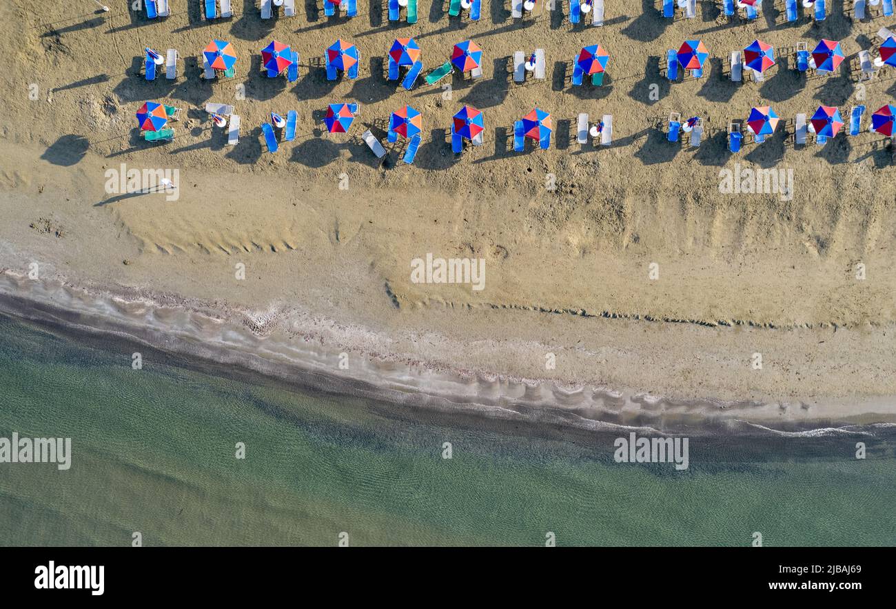 Drohnenantenne von Sonnenschirmen am Strand. Sommerurlaub im Meer Stockfoto