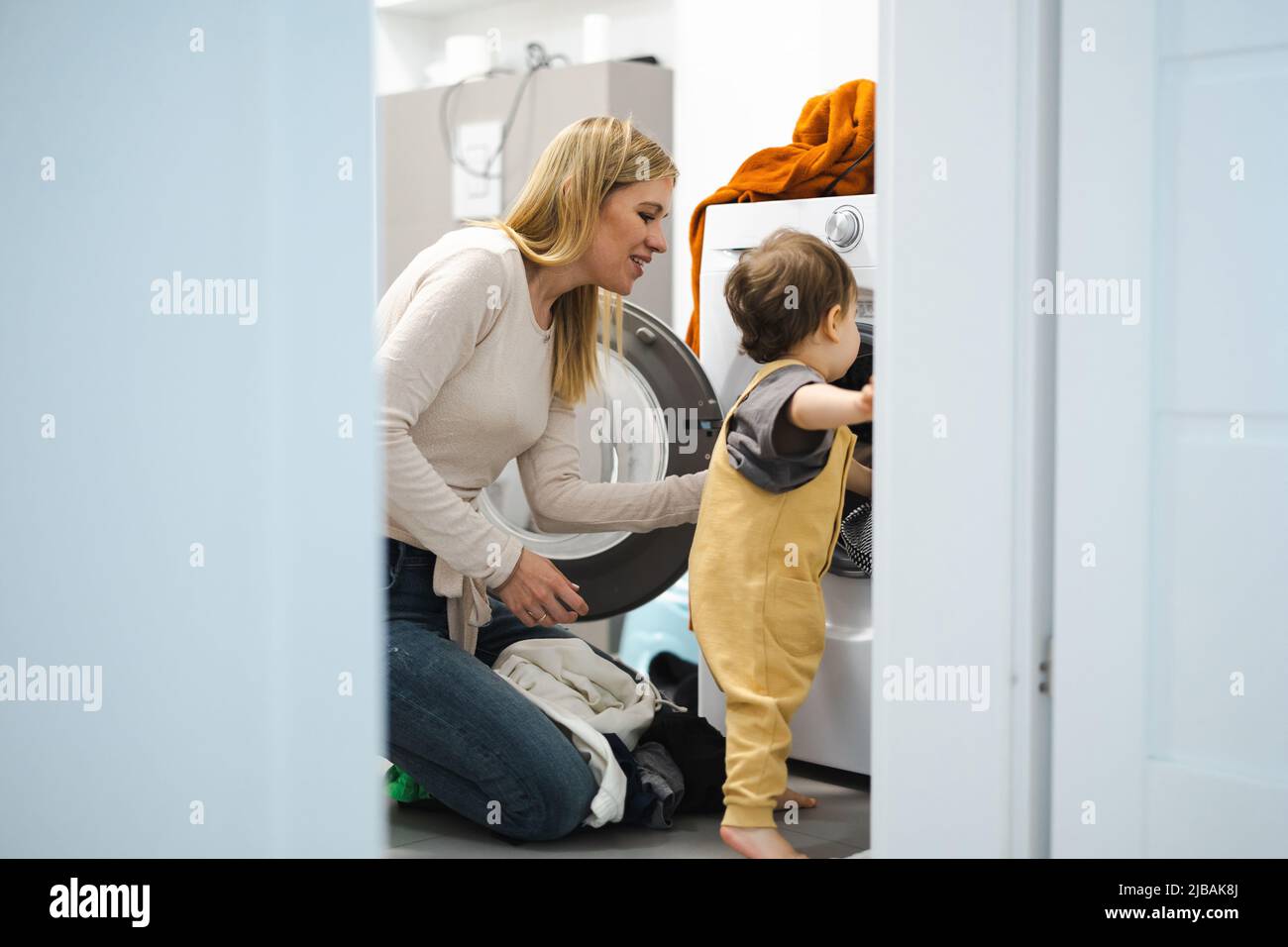 Mutter und Sohn laden Waschmaschine Stockfoto