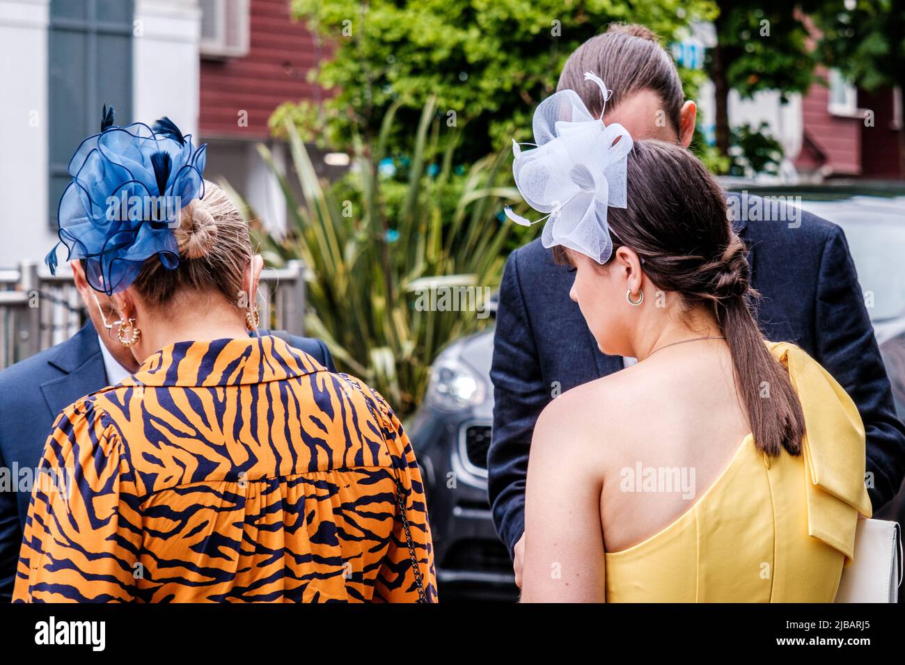 Epsom Surrey, London, Großbritannien, Juni 04 2022, Frau mit leuchtendem Kleid mit Tiger-Druck und blauer Kopfbedeckung als Faszinator Stockfoto