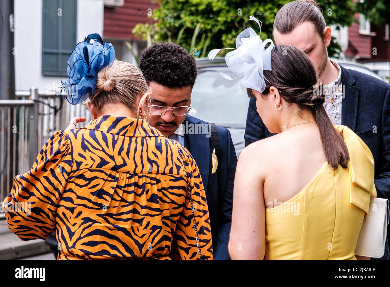 Epsom Surrey, London, Großbritannien, Juni 04 2022, Frau mit leuchtendem Kleid mit Tiger-Druck und blauer Kopfbedeckung als Faszinator Stockfoto